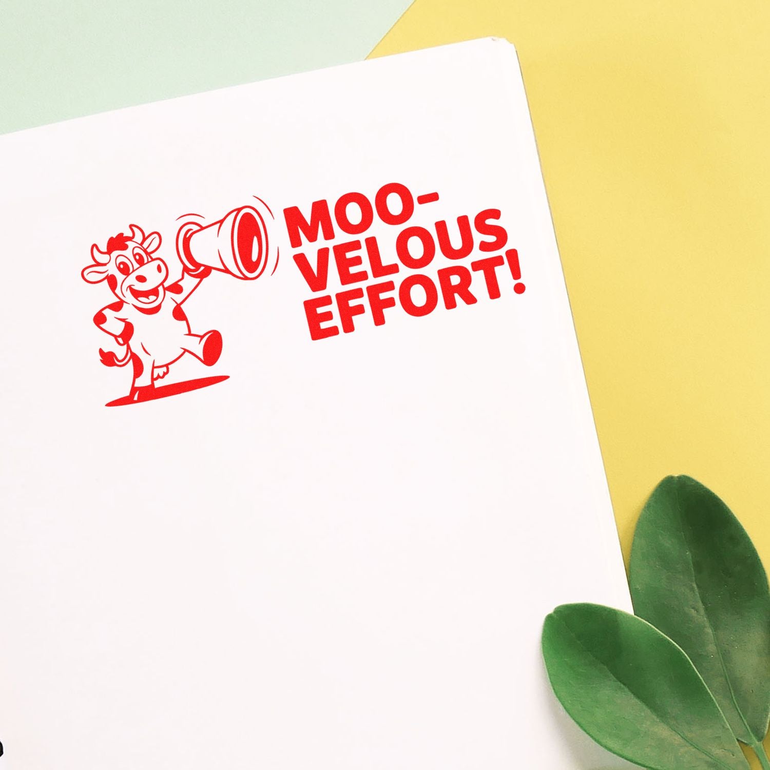 Red cow stamp with megaphone and MOO-VELOUS EFFORT! on white card, set on yellow background with green leaves.