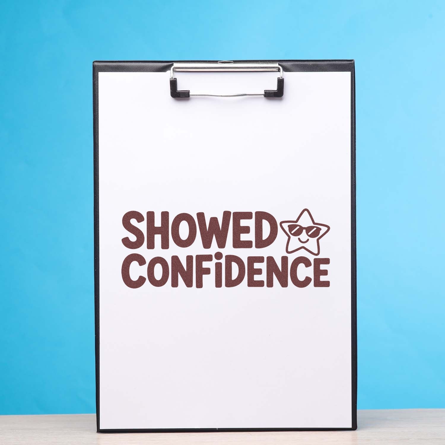 Clipboard displaying brown Showed Confidence stamp and star seal on white paper against a bright blue background.