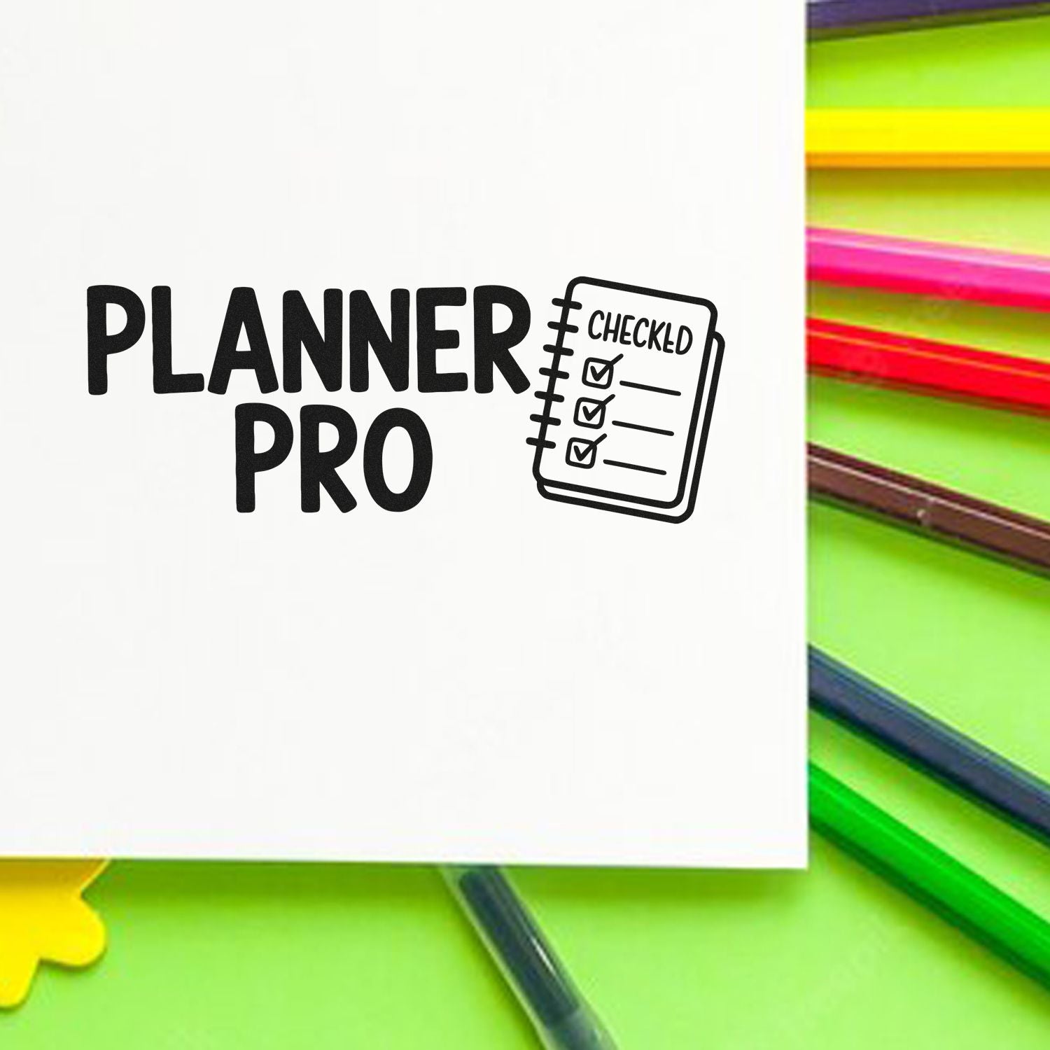 Black Planner Pro checklist stamp on white sheet, with neon green, pink and yellow seal tabs in the background.