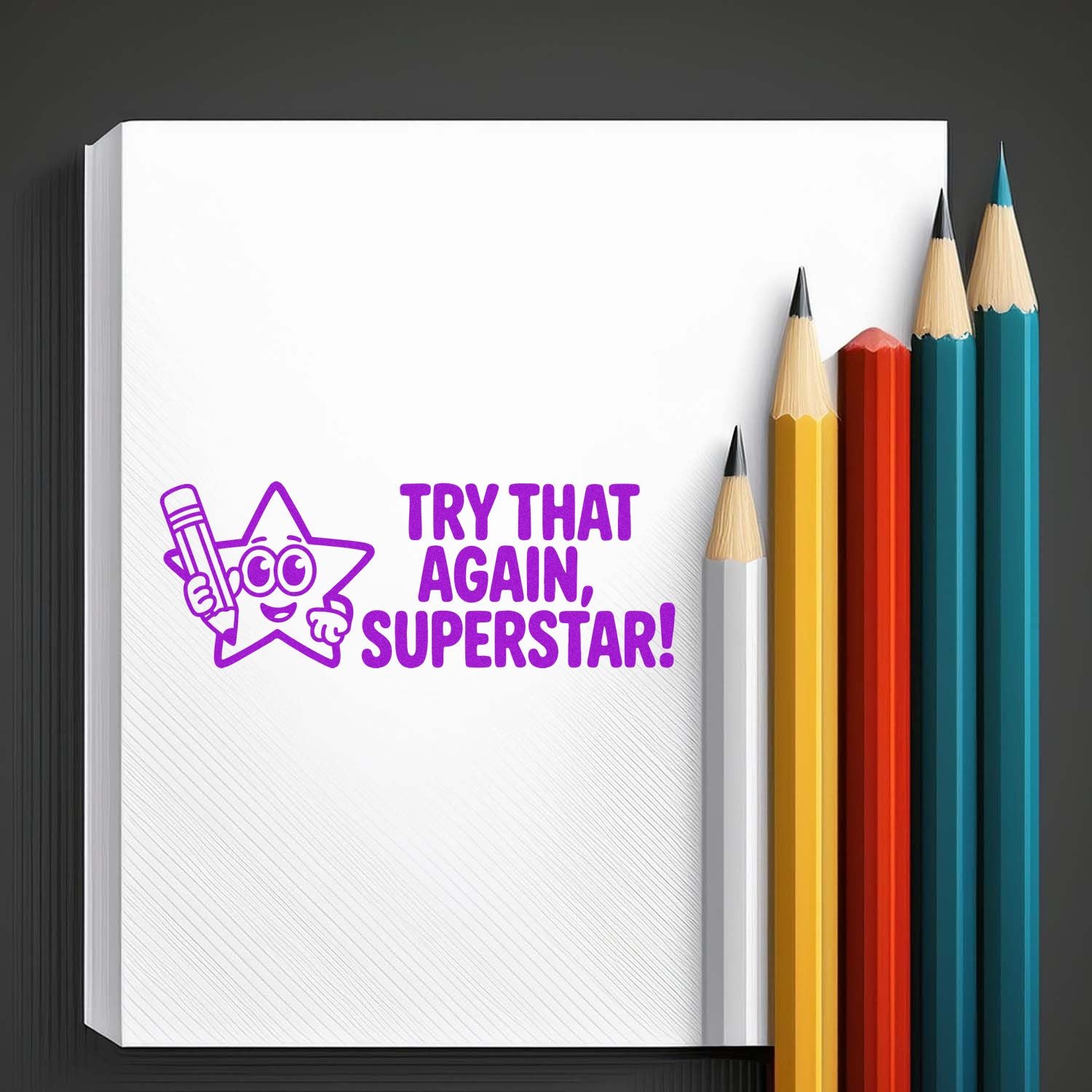 Purple motivational stamp and seal reading Try that again, superstar! on white notebook page with colorful pencils.