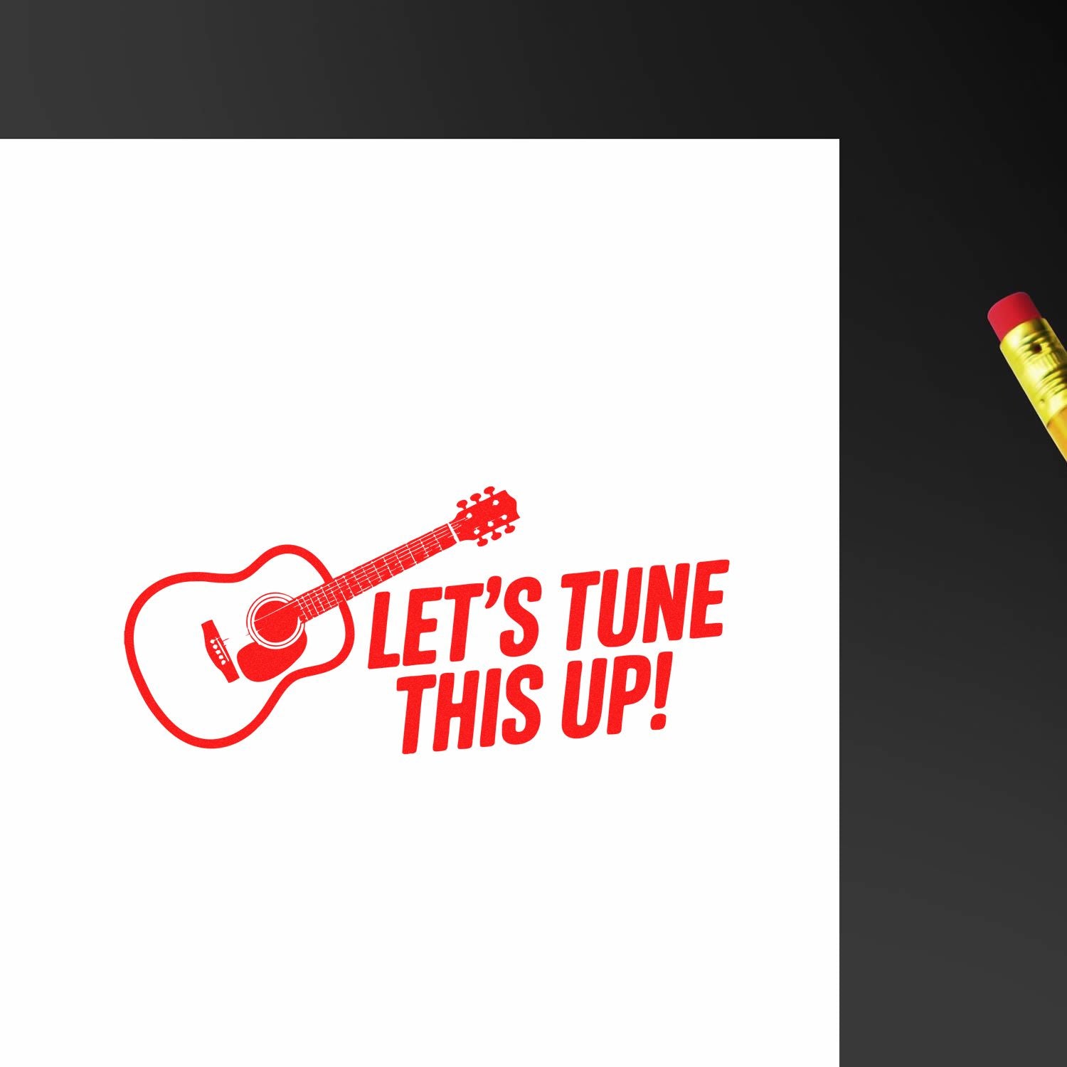 Red guitar stamp and seal with LETS TUNE THIS UP! on white paper, accented by a yellow pencil.