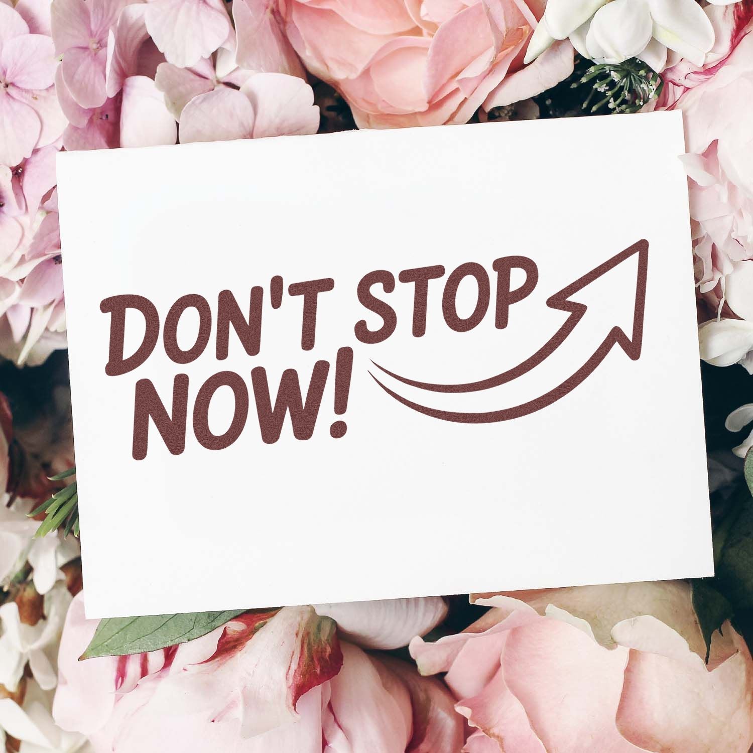 Brown DONT STOP NOW! stamp and seal design on white card, with arrow, surrounded by soft pink flowers.