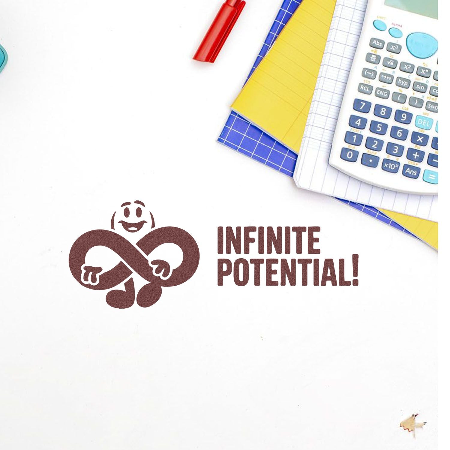 Brown rubber stamp seal with smiling infinity character and INFINITE POTENTIAL! text on white, beside colorful notebooks and calculator.