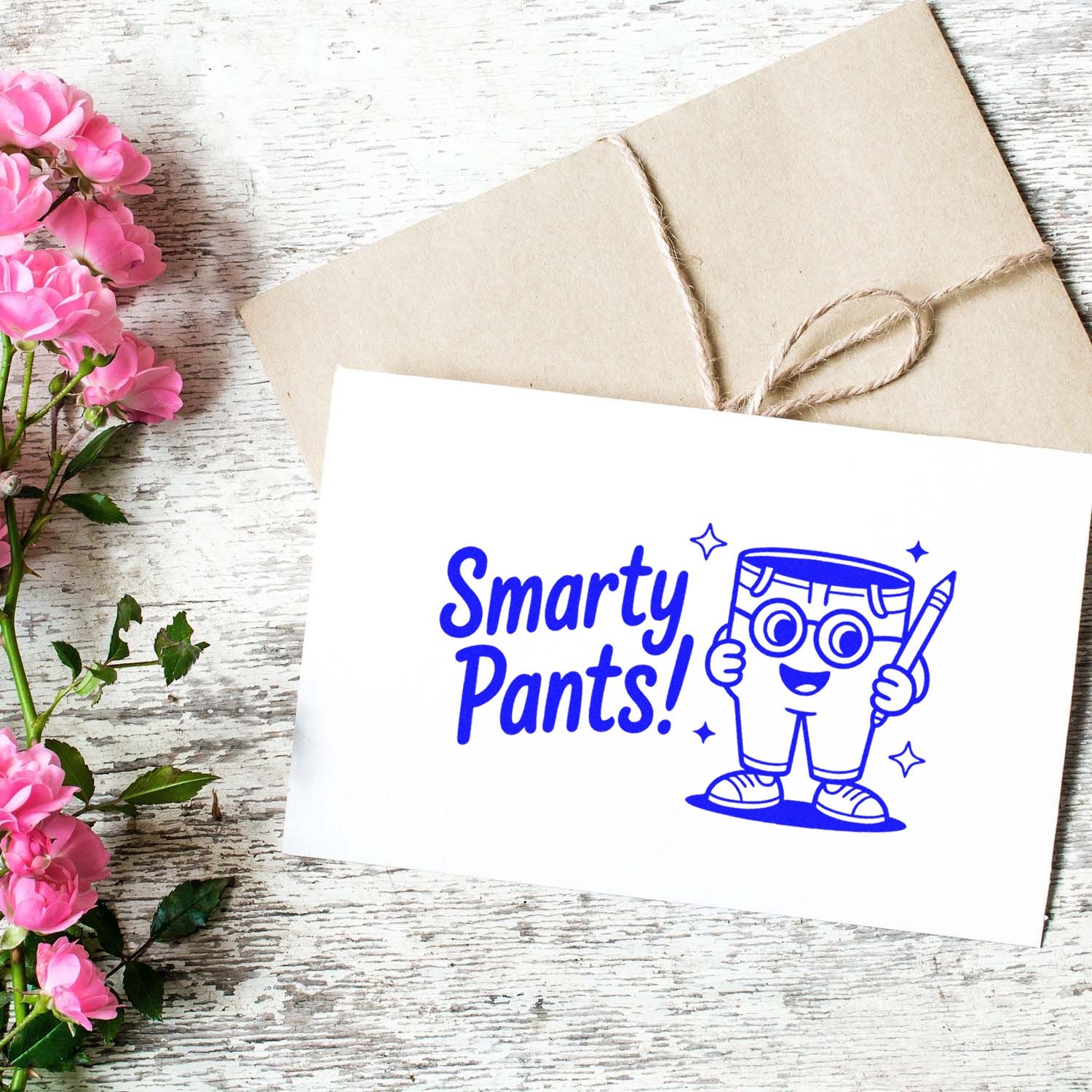 Blue Smarty Pants! stamp and seal design on white card, with cartoon pencil mascot, tan twine-wrapped envelope, and pink flowers.