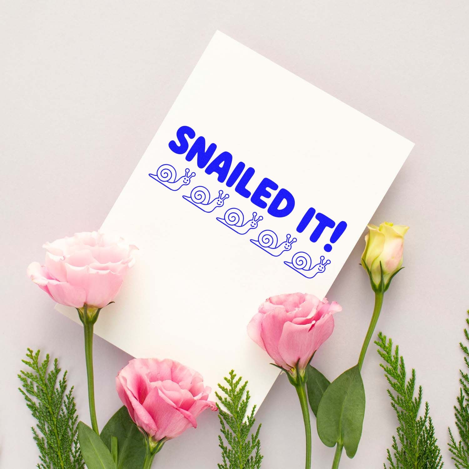 White card with blue SNAILED IT! stamp and snail seal icons, framed by pink flowers and green leaves.
