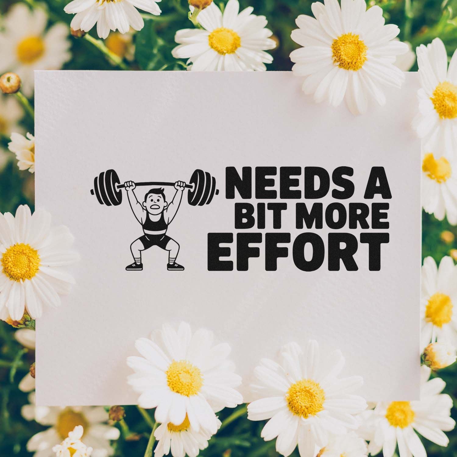 Black motivational stamp/seal design with weightlifter icon and NEEDS A BIT MORE EFFORT on white card, framed by white daisies.