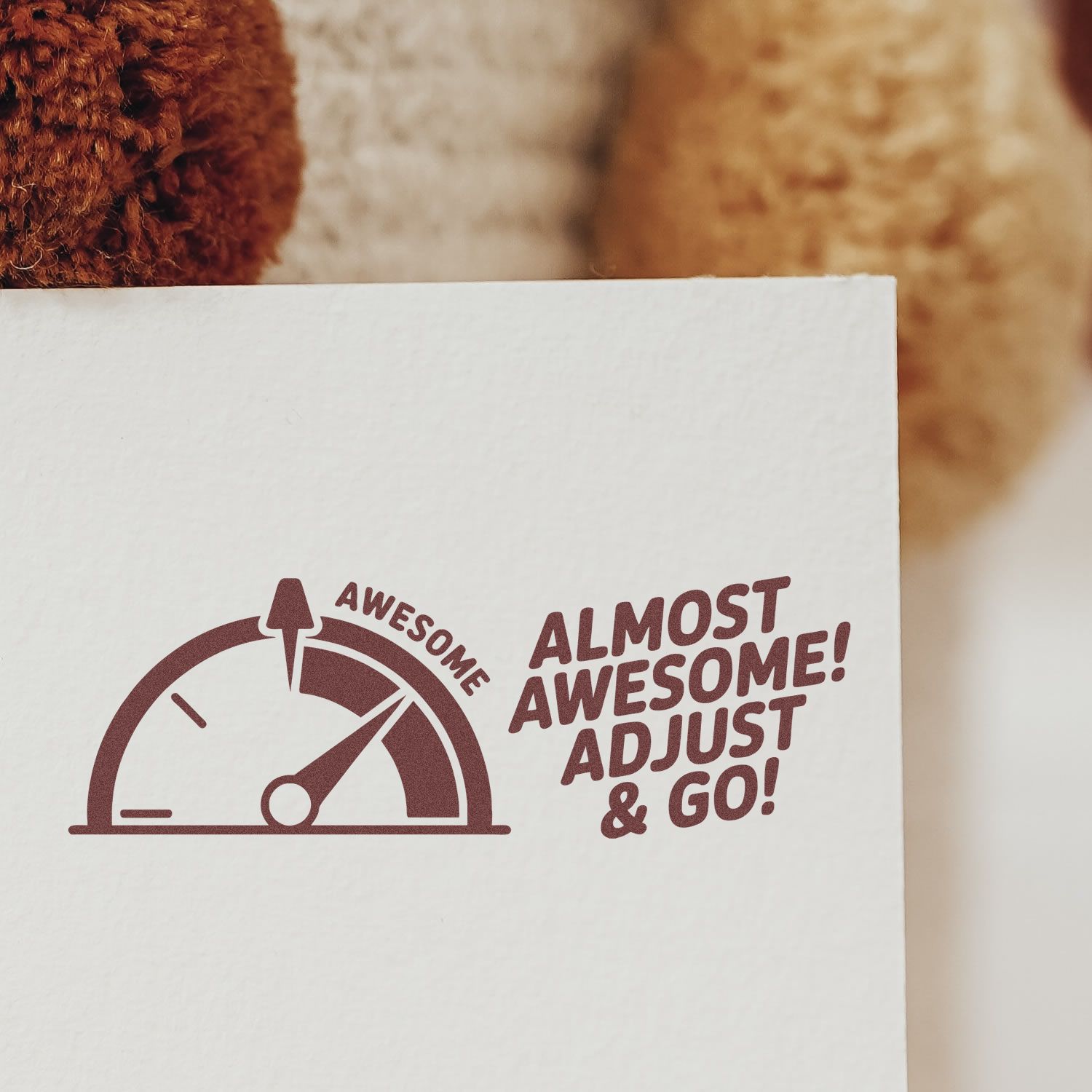 Maroon rubber stamp seal with gauge icon and Almost Awesome! Adjust & Go! on white paper.