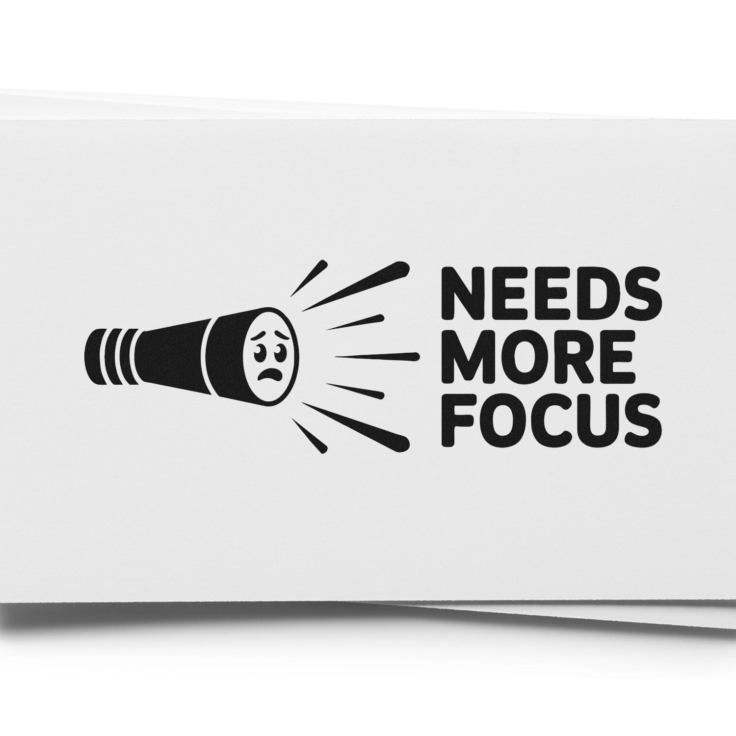 Black-and-white rubber stamp/seal with sad flashlight icon and bold text, NEEDS MORE FOCUS.