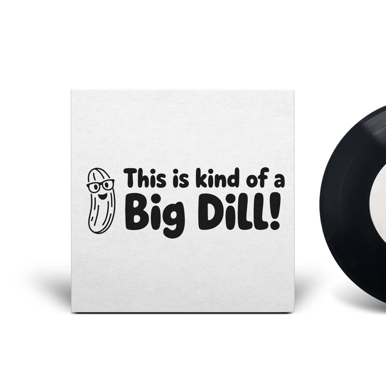 White stamp and seal with black This is kind of a Big Dill! text, smiling pickle cartoon, and partial black seal.