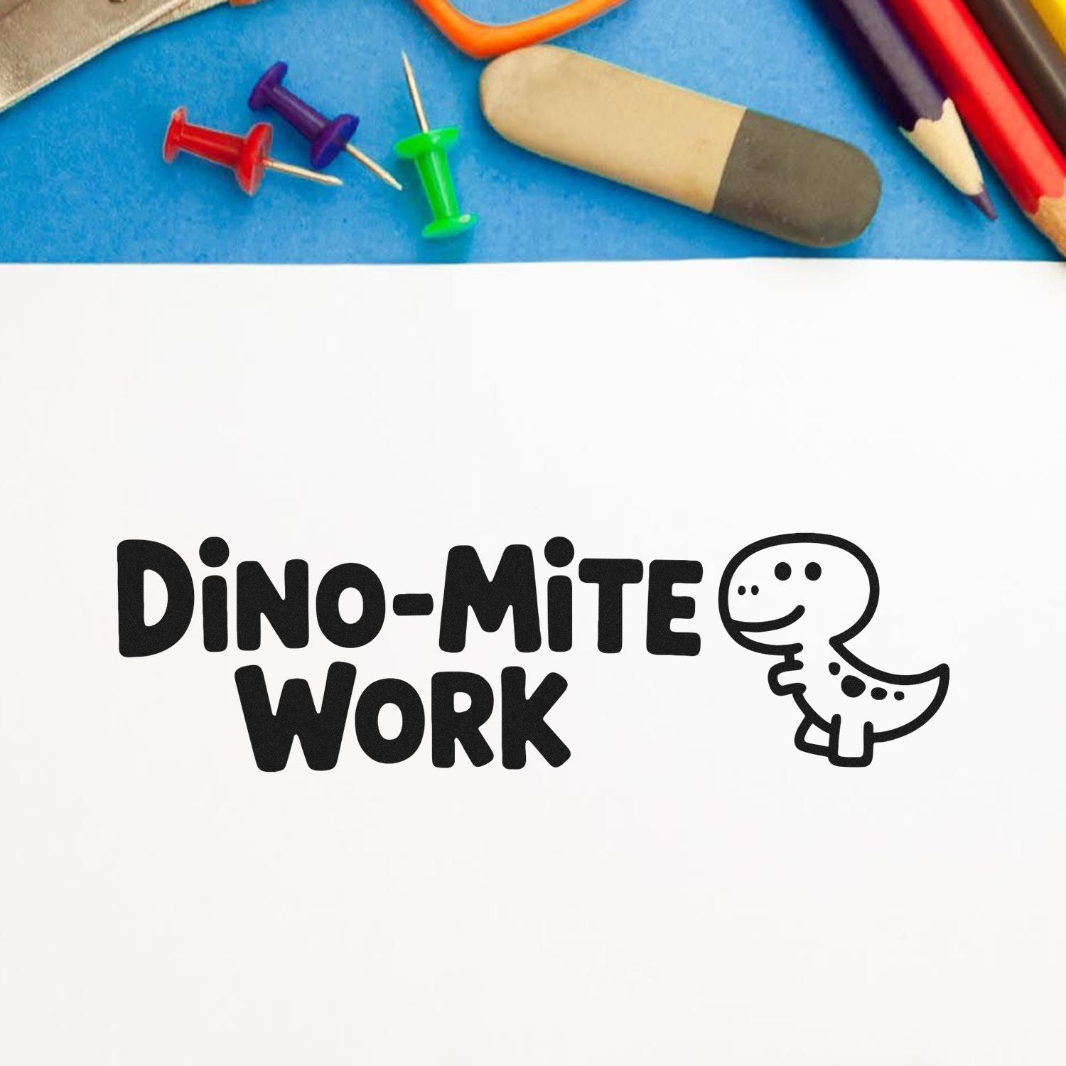 Black Dino-Mite Work stamp seal with cartoon dinosaur on white, framed by colorful push pins, pencils, and eraser.
