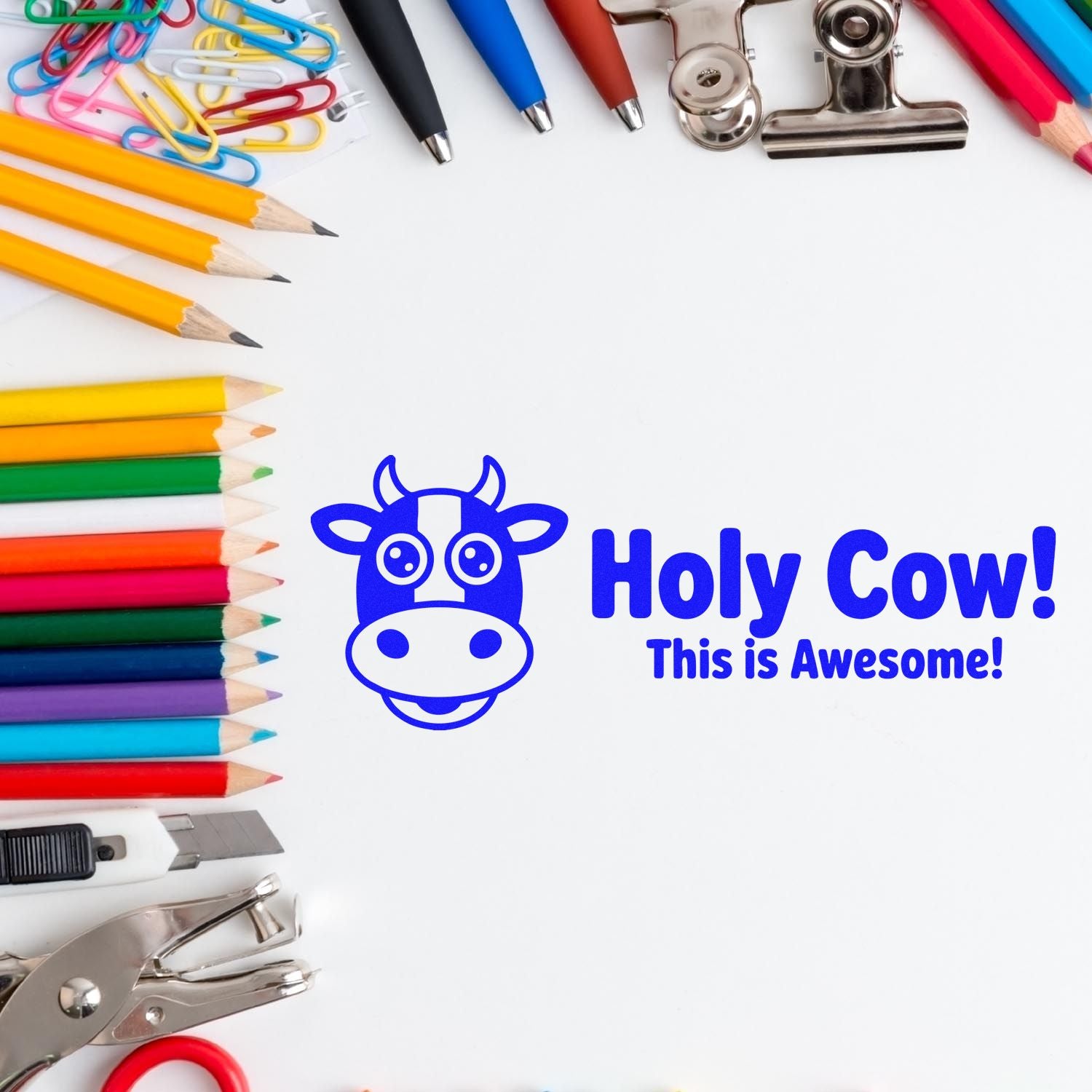 Blue cow stamp and seal reading Holy Cow! This is Awesome! with colorful pencils, clips, and office tools.