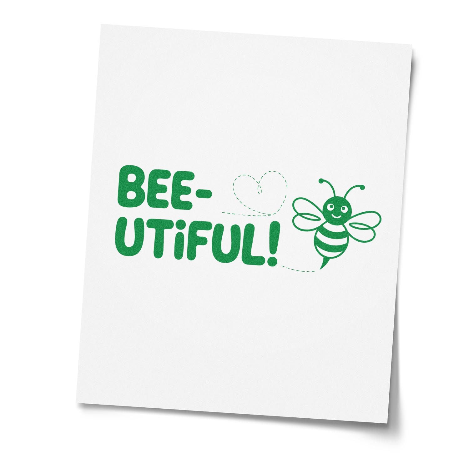 Green BEE-UTIFUL! stamp seal with a smiling bee, heart doodle, and dotted trail on white paper.