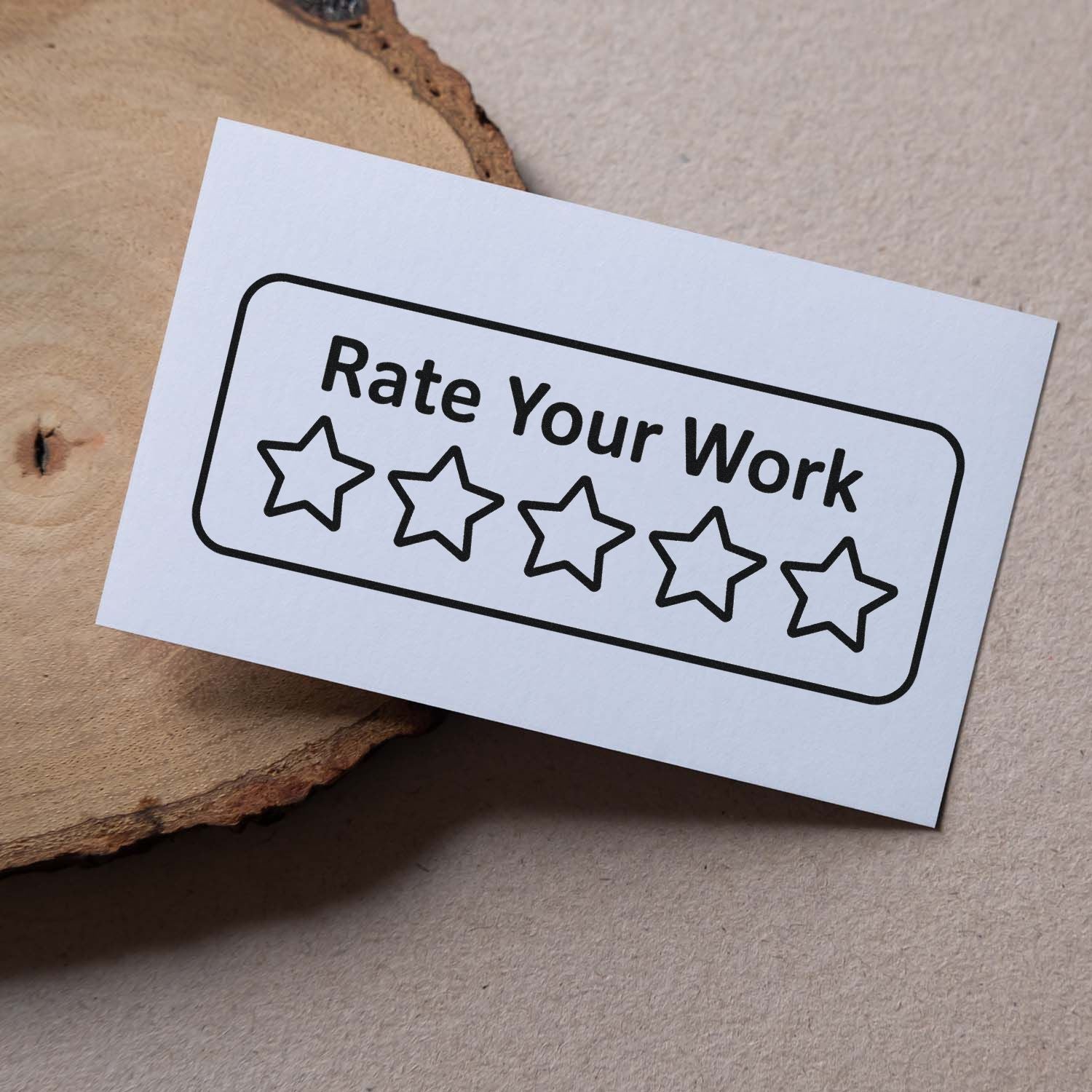White stamp-and-seal card with black Rate Your Work text and five outlined stars on a beige wood background.
