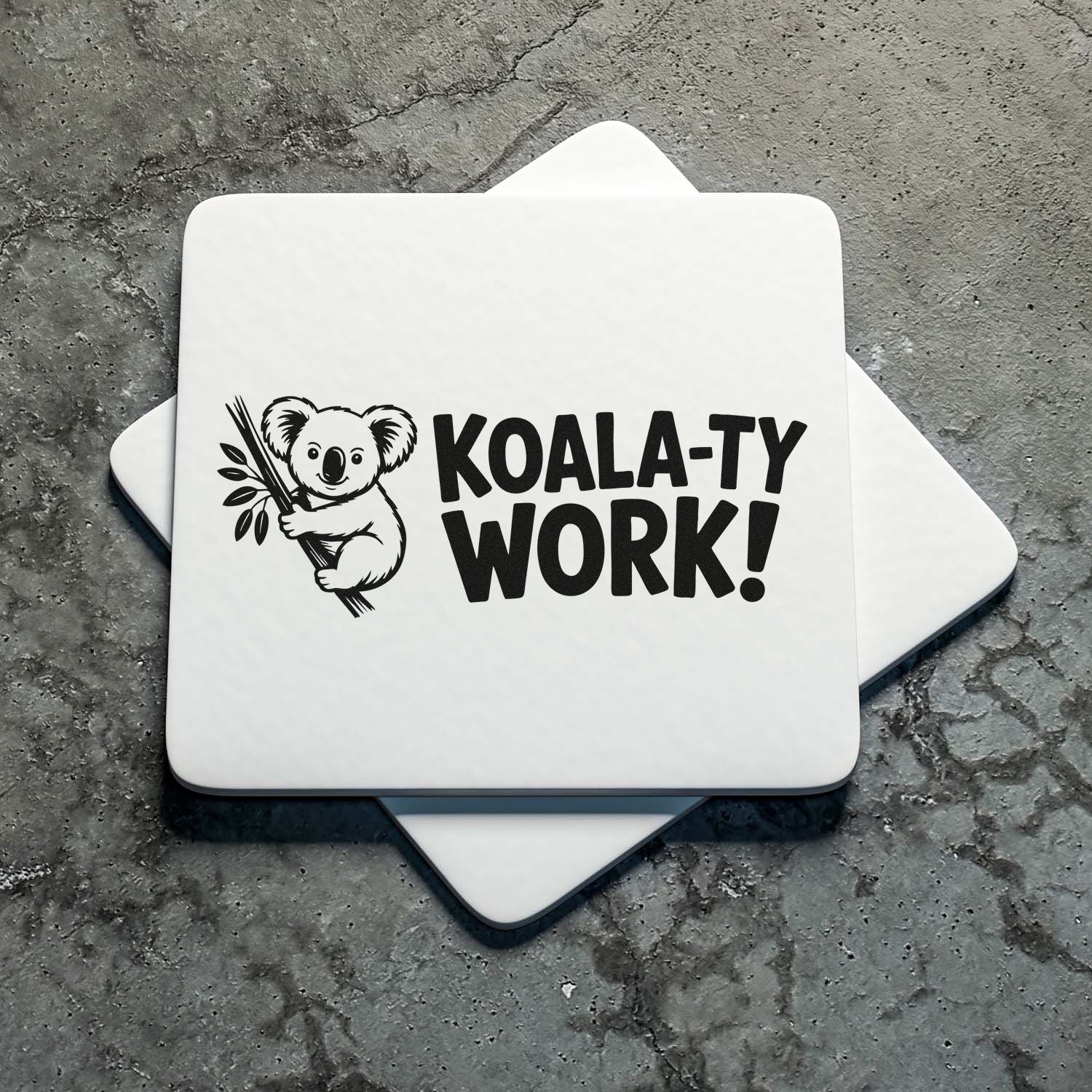 White custom stamp and seal blocks with black koala graphic and bold KOALA-TY WORK! text on gray stone.