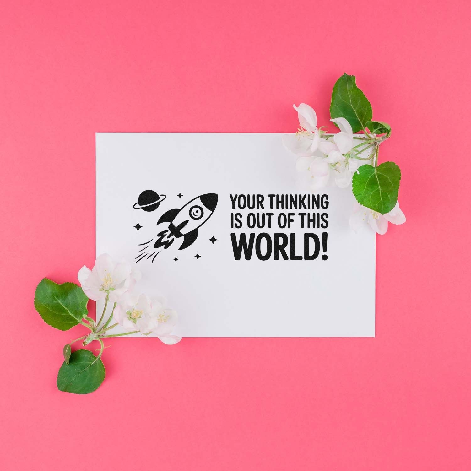 Black rocket custom stamp on white card with Your thinking is out of this world! on pink background, with flowers and leaves.