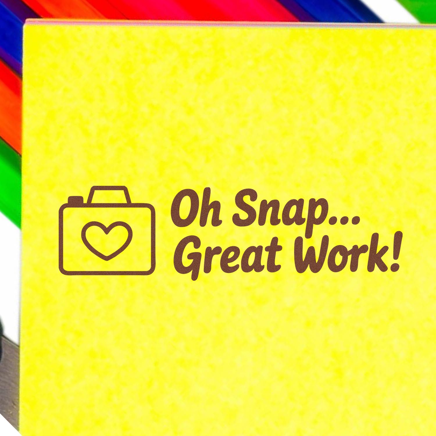 Yellow stamp and seal pad with brown heart icon and Oh Snap... Great Work! text, framed by rainbow edges.