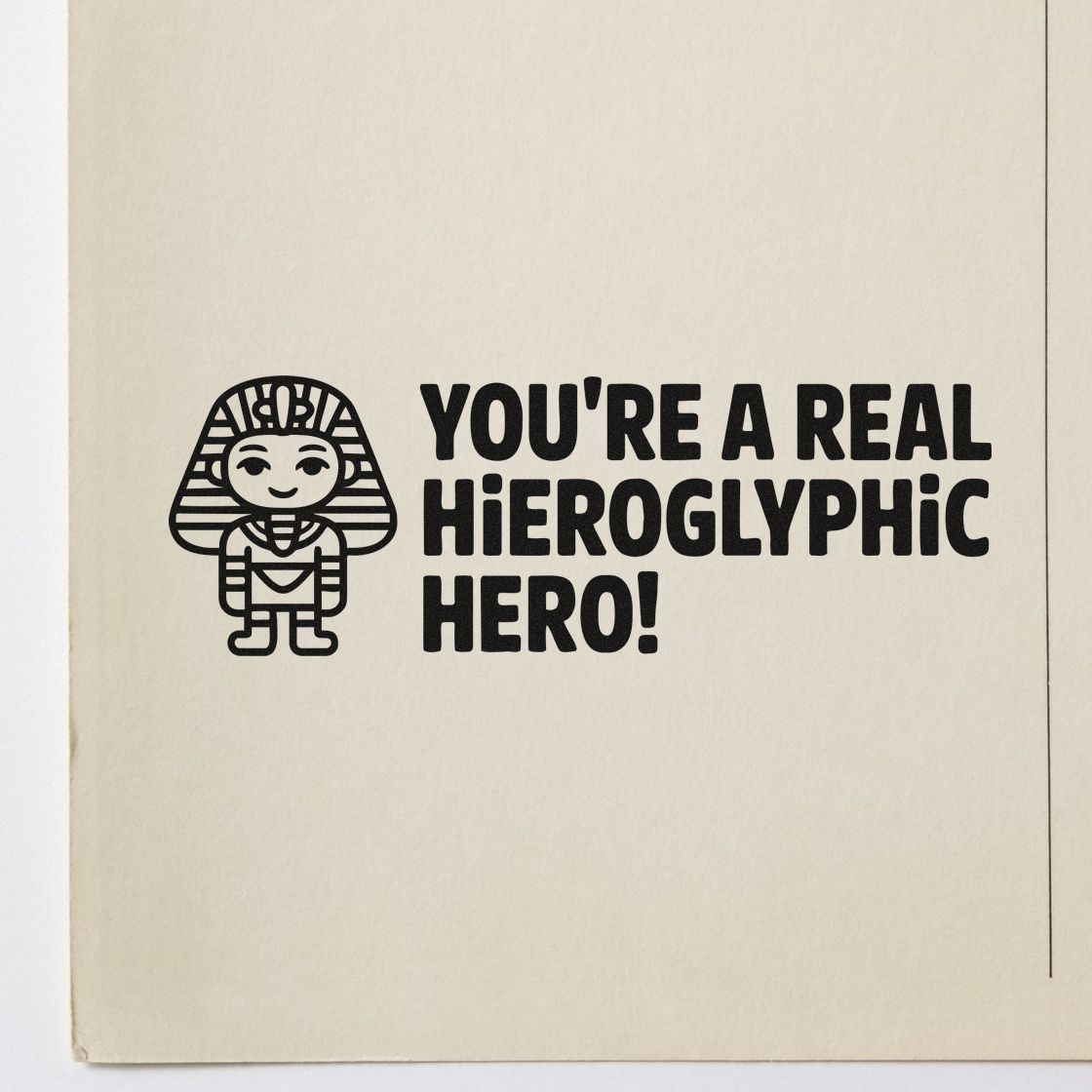 Black stamp and seal featuring an Egyptian pharaoh and the text Youre a real hieroglyphic hero! on cream paper.