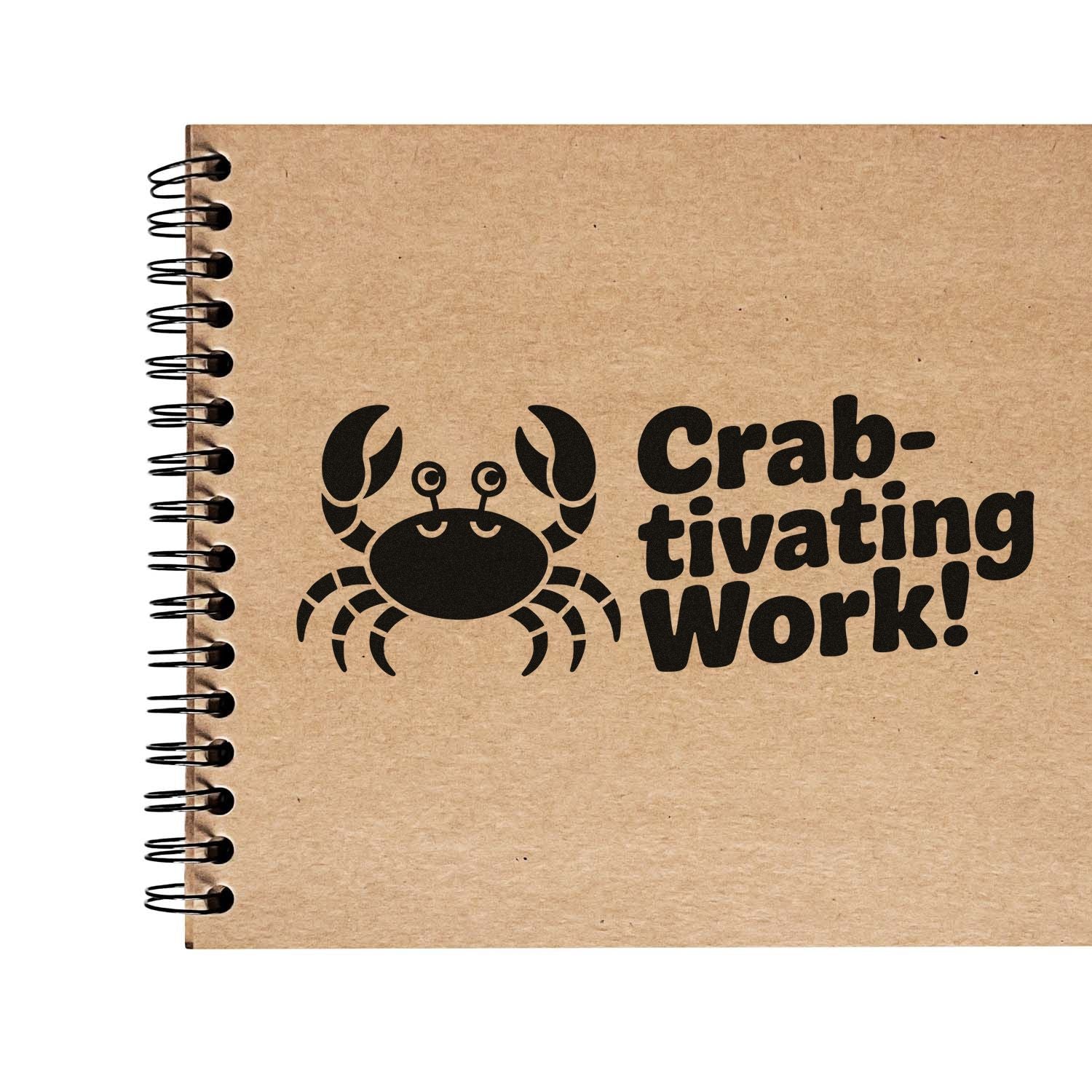 Black crab stamp seal on kraft paper notebook with Crab-tivating Work! and spiral binding.