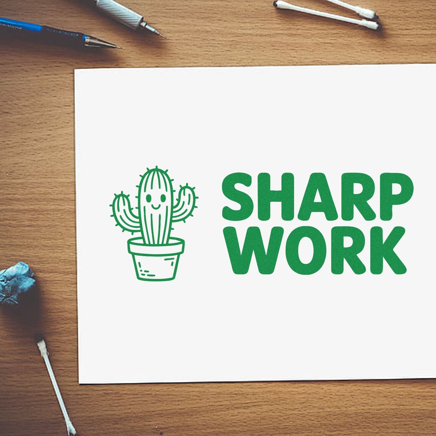 Green cactus logo and SHARP WORK stamp on white card, with pens and seal tools on a wooden desk.