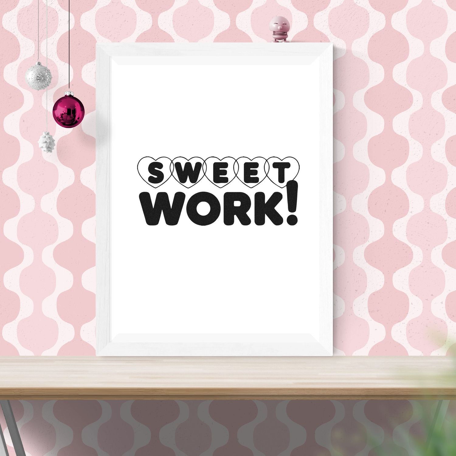 Black SWEET WORK! stamp and seal design with heart outlines in a white frame on a pink patterned background