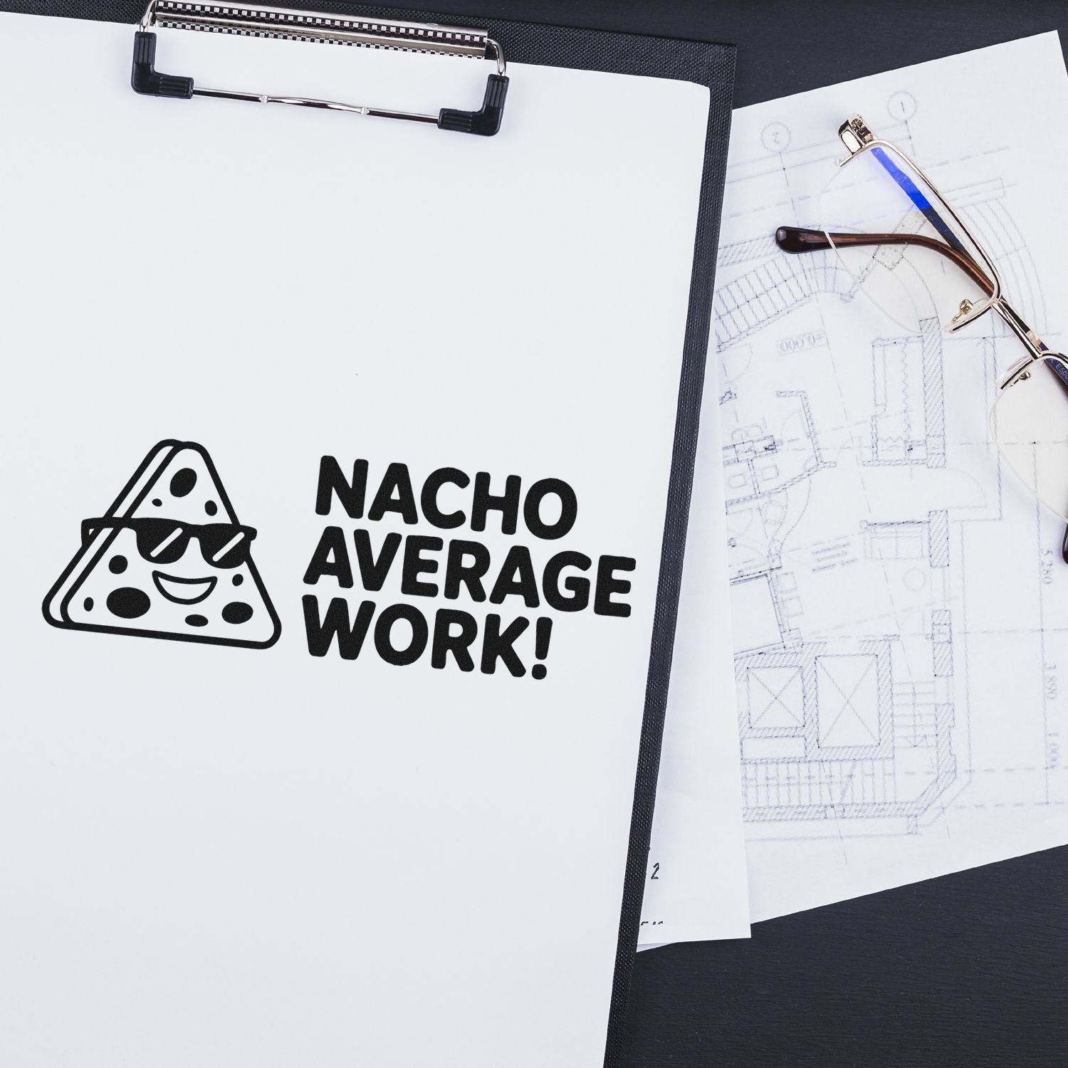 Black custom stamp and seal reading NACHO AVERAGE WORK! with pizza icon on white clipboard beside eyeglasses and blueprints.