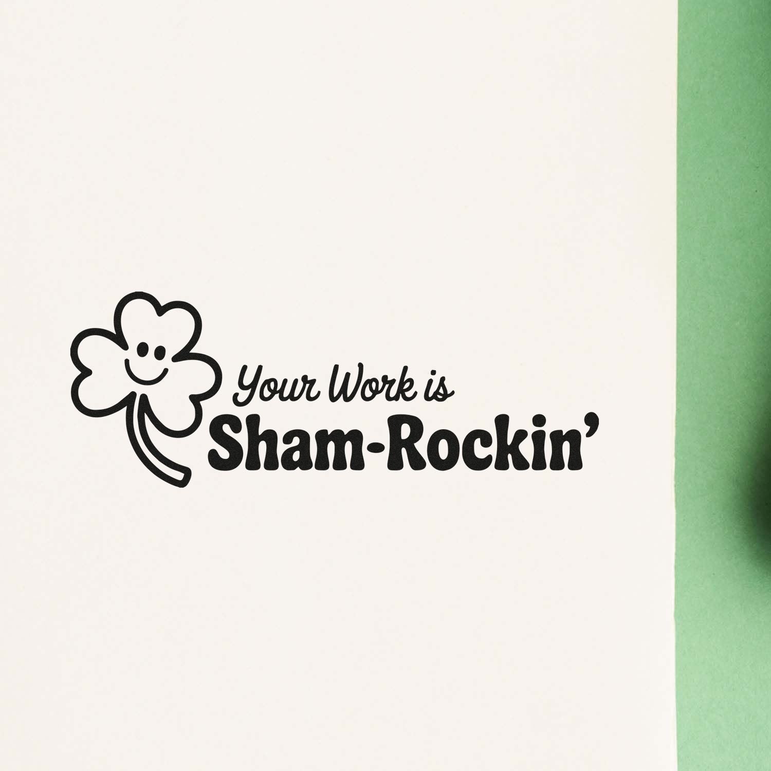 Black shamrock stamp seal with smiling clover and Your Work is Sham-Rockin on white paper with green edge