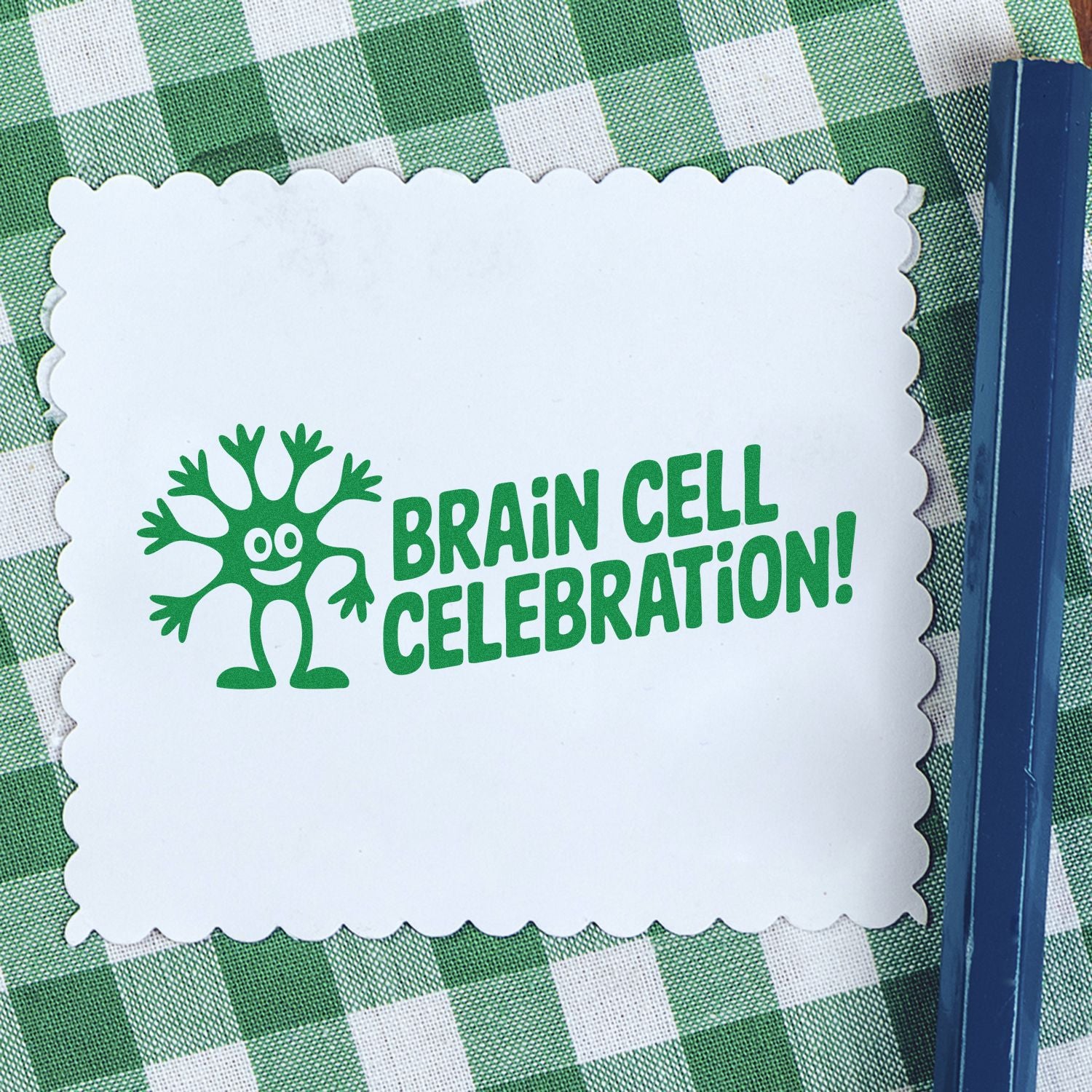 White scalloped stamp/seal card with green Brain Cell Celebration! text and mascot on green gingham, blue tool at right