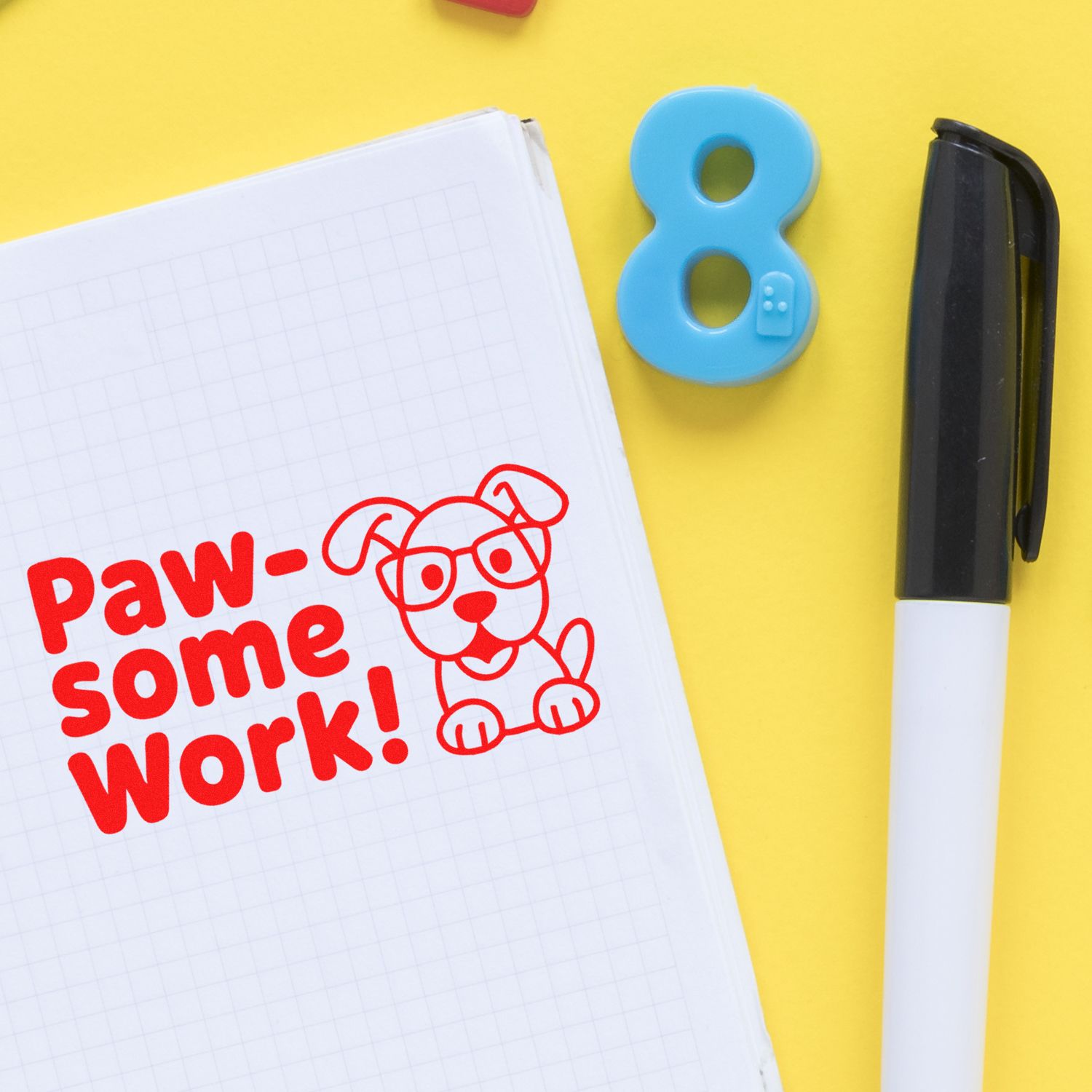 Red Paw-some Work! stamp on graph notebook with blue number 8 seal and black-and-white stamp pen on yellow background.