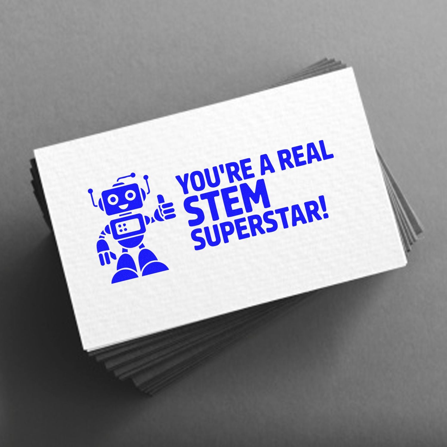 Blue STEM Superstar robot stamp on stacked white seal cards, with bold blue text on a gray background