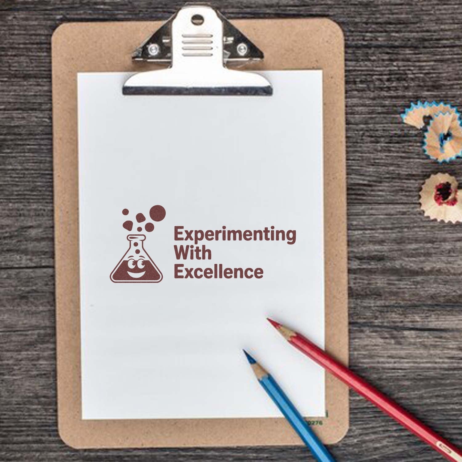Brown clipboard with white paper showing maroon lab stamp seal Experimenting With Excellence, plus red and blue pencils