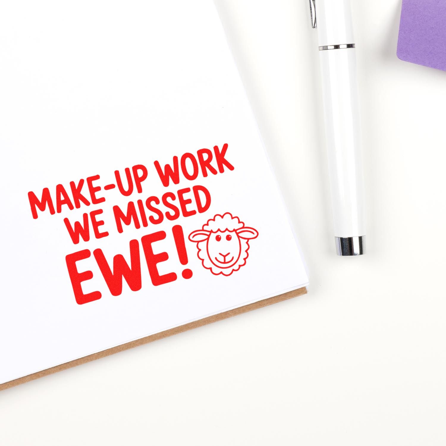 Red make-up work we missed ewe rubber stamp and seal with sheep icon on white card, beside a white pen and purple paper.