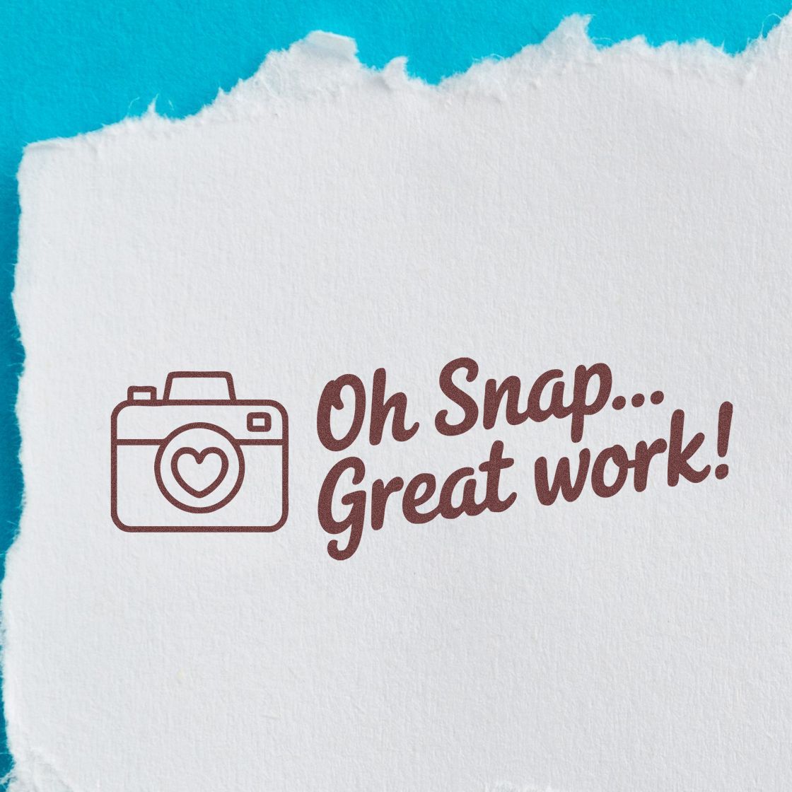 Brown rubber stamp seal with camera icon and Oh Snap... Great work! on white textured paper against turquoise background.