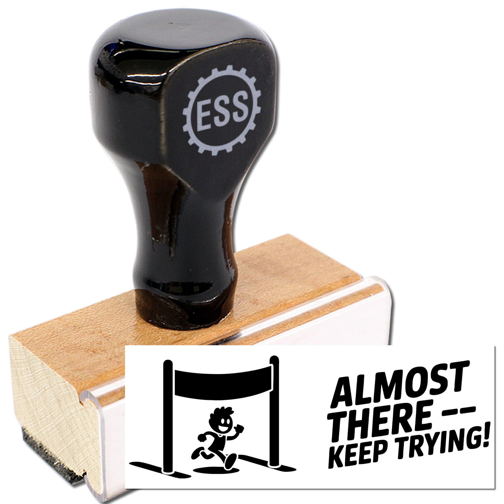 Black rubber stamp and wooden seal block with ESS logo, showing bold Almost therekeep trying! imprint.
