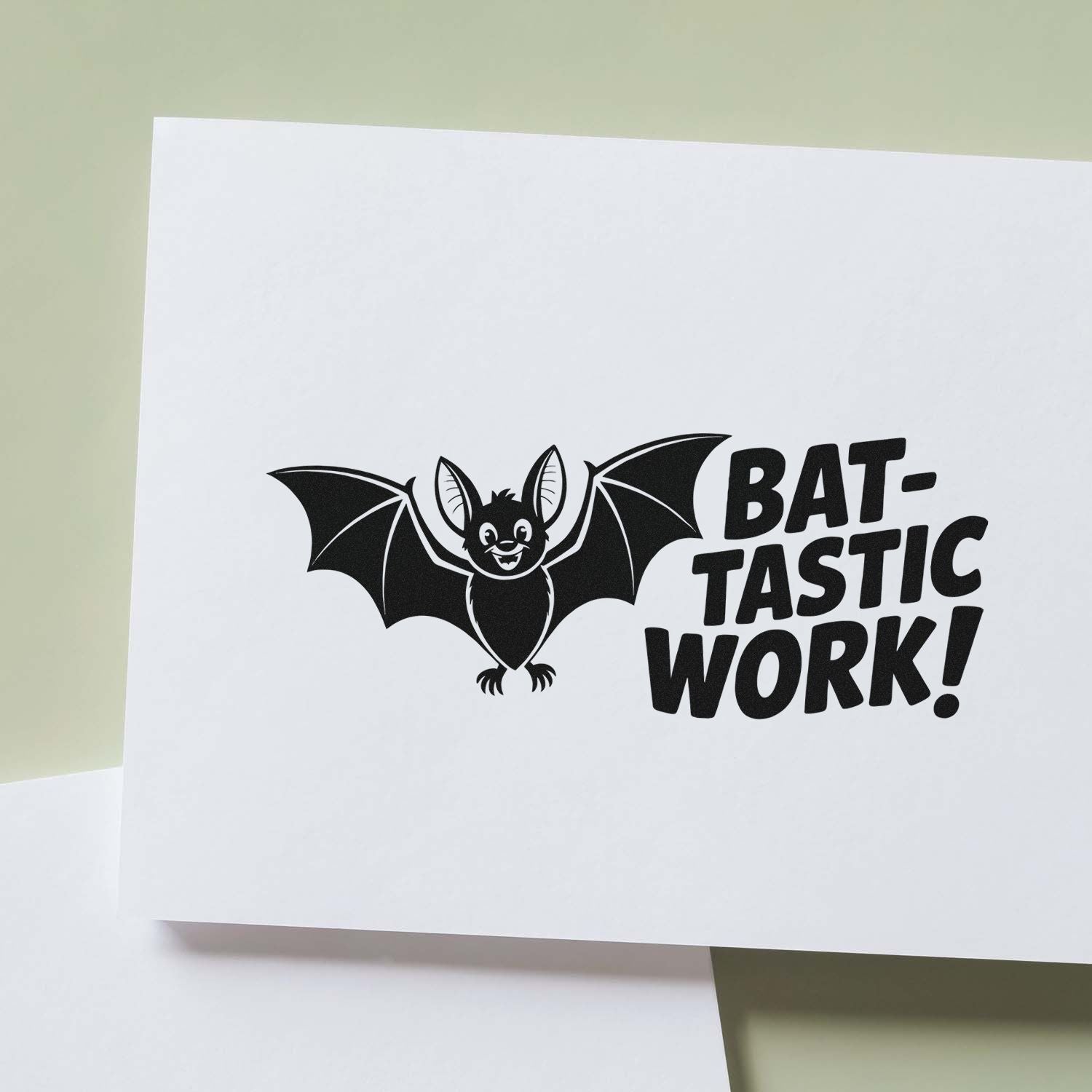 Black bat stamp seal with BAT-TASTIC WORK! on white cardstock, set against a pale green background.