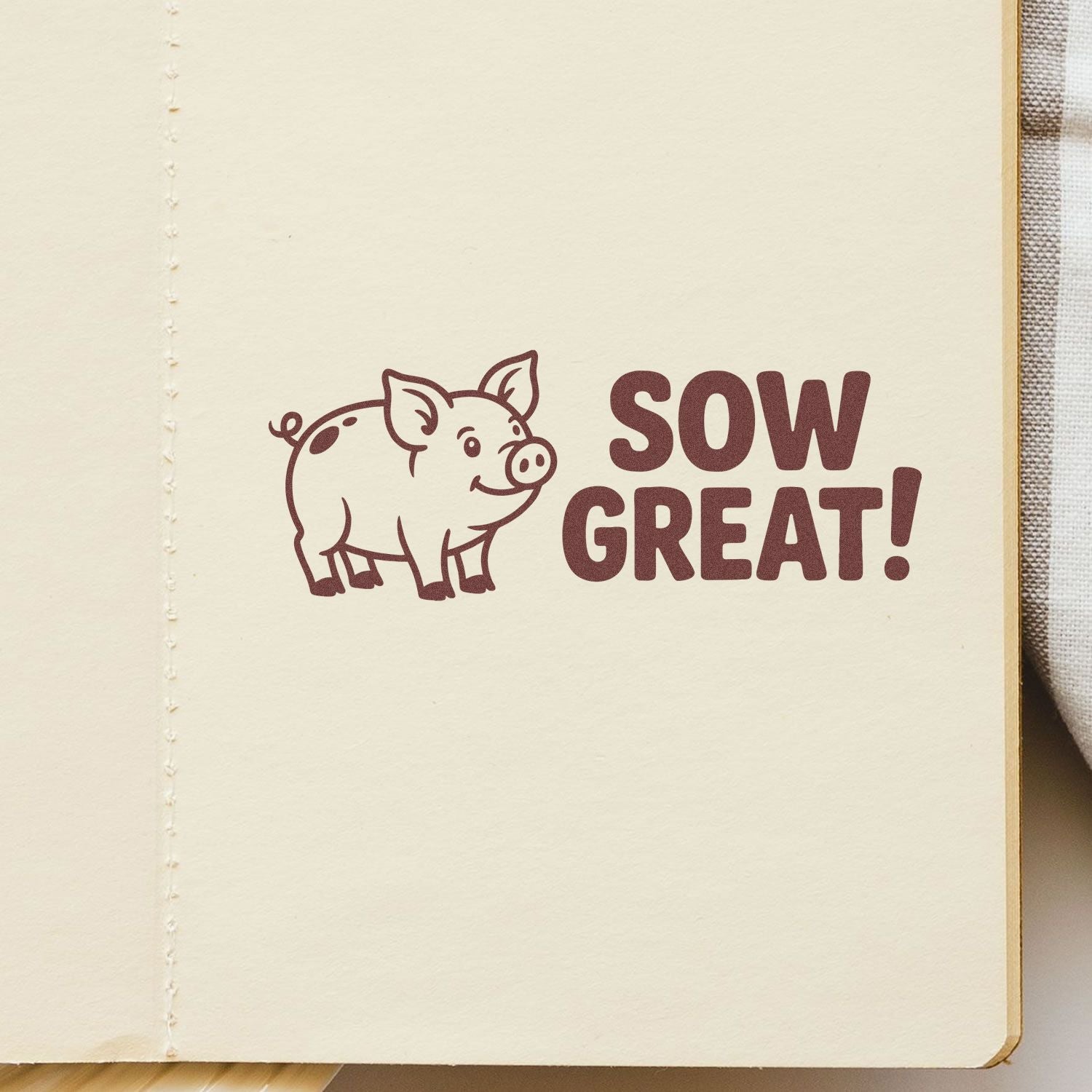 Maroon pig stamp and seal reading SOW GREAT! on cream paper