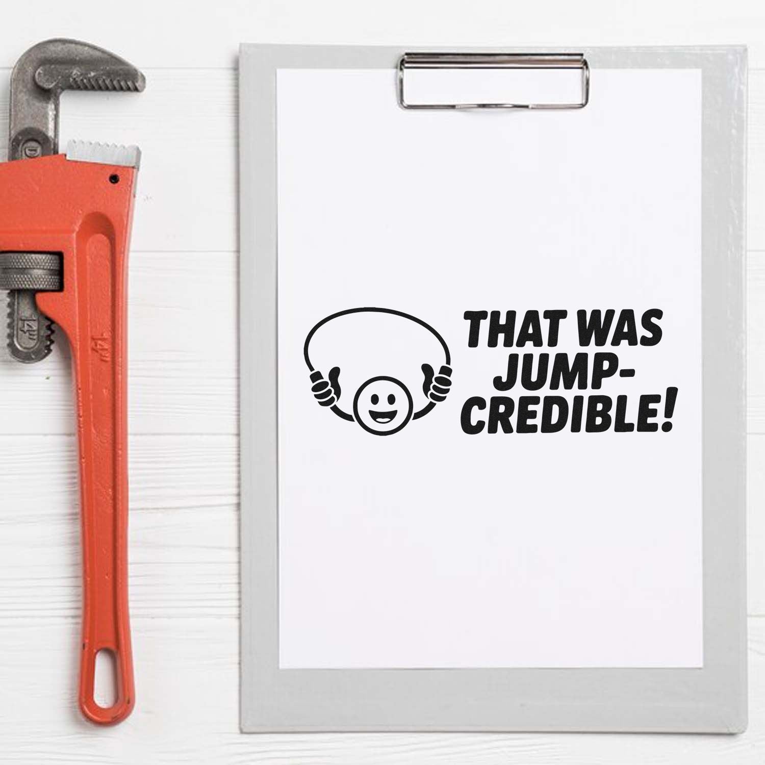 Orange pipe wrench beside a clipboard with a black stamp/seal reading "That was jump-credible!" and a smiling jumper icon.