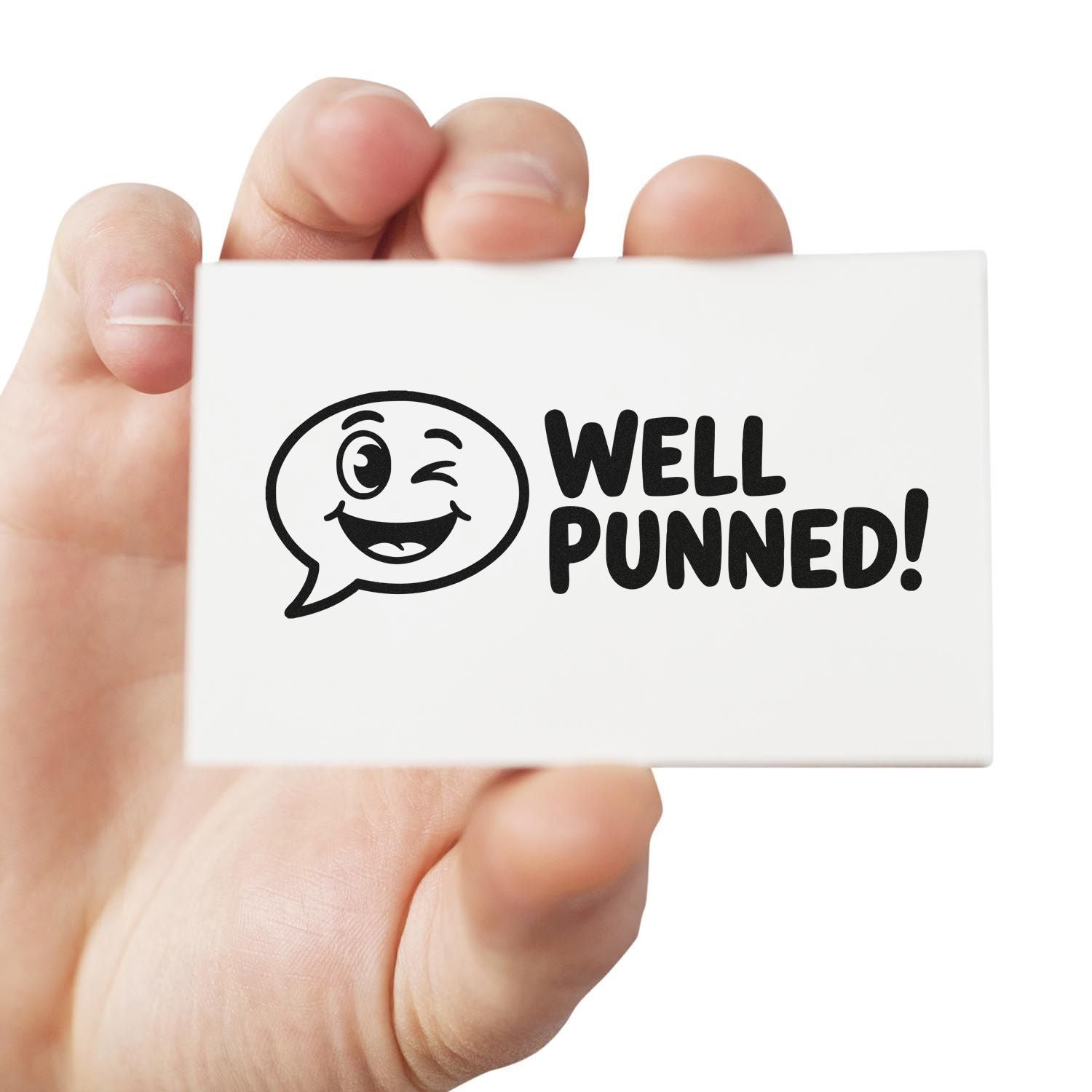 Hand holding white rubber stamp seal with black winking face and WELL PUNNED! text