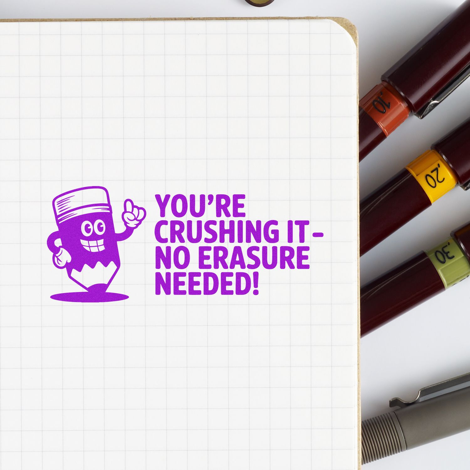 Purple motivational stamp reading Youre crushing itno erasure needed! on grid paper, with colorful numbered stamp and seal markers.