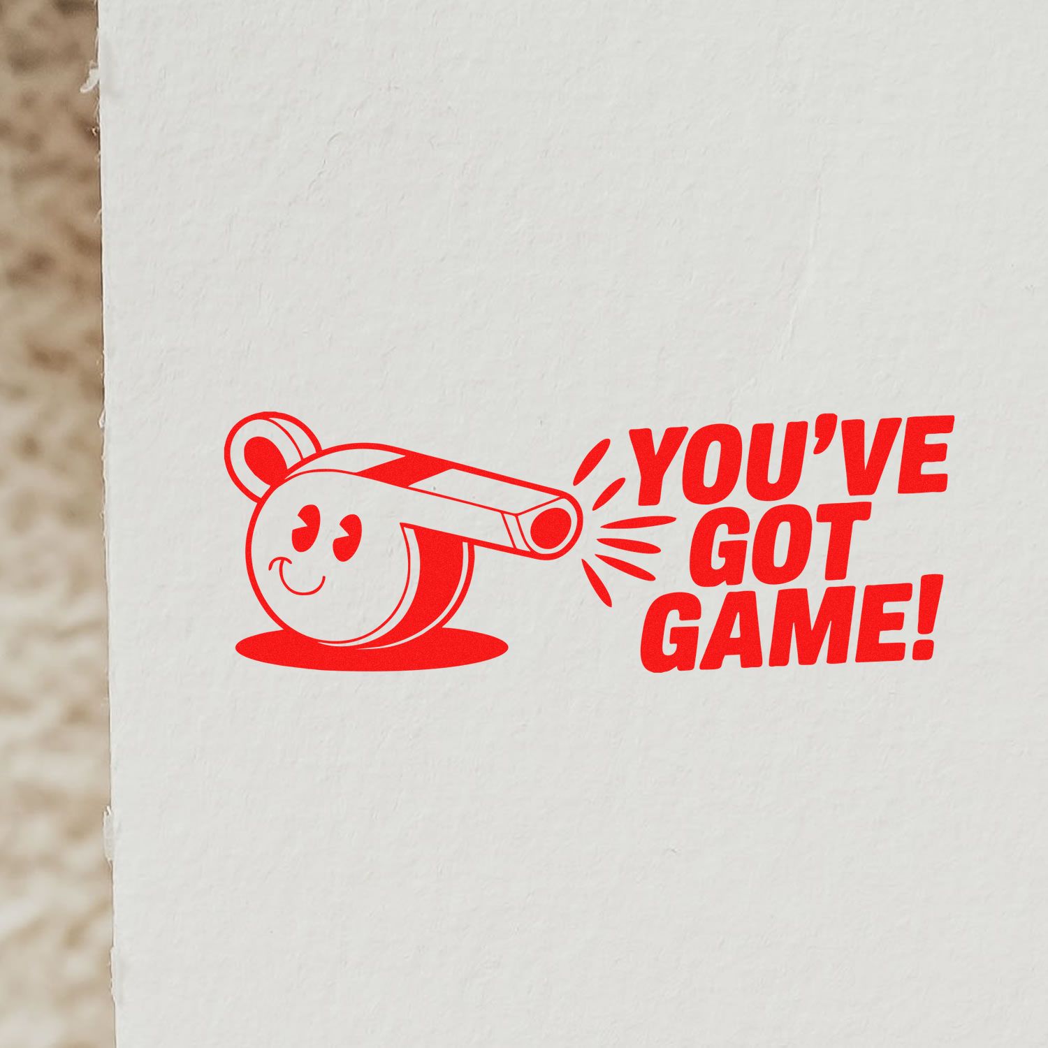 Red rubber stamp seal with smiling whistle and bold YOUVE GOT GAME! text on a white background.