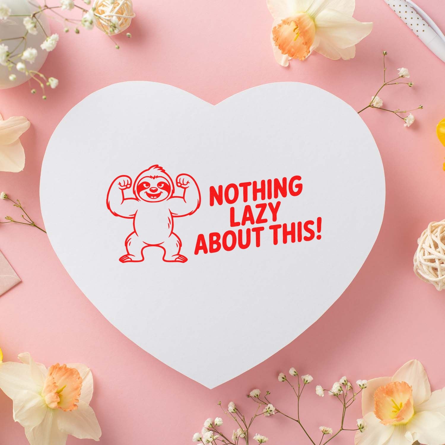 White heart-shaped stamp and seal card with red sloth graphic and Nothing Lazy About This! on a pink floral background.