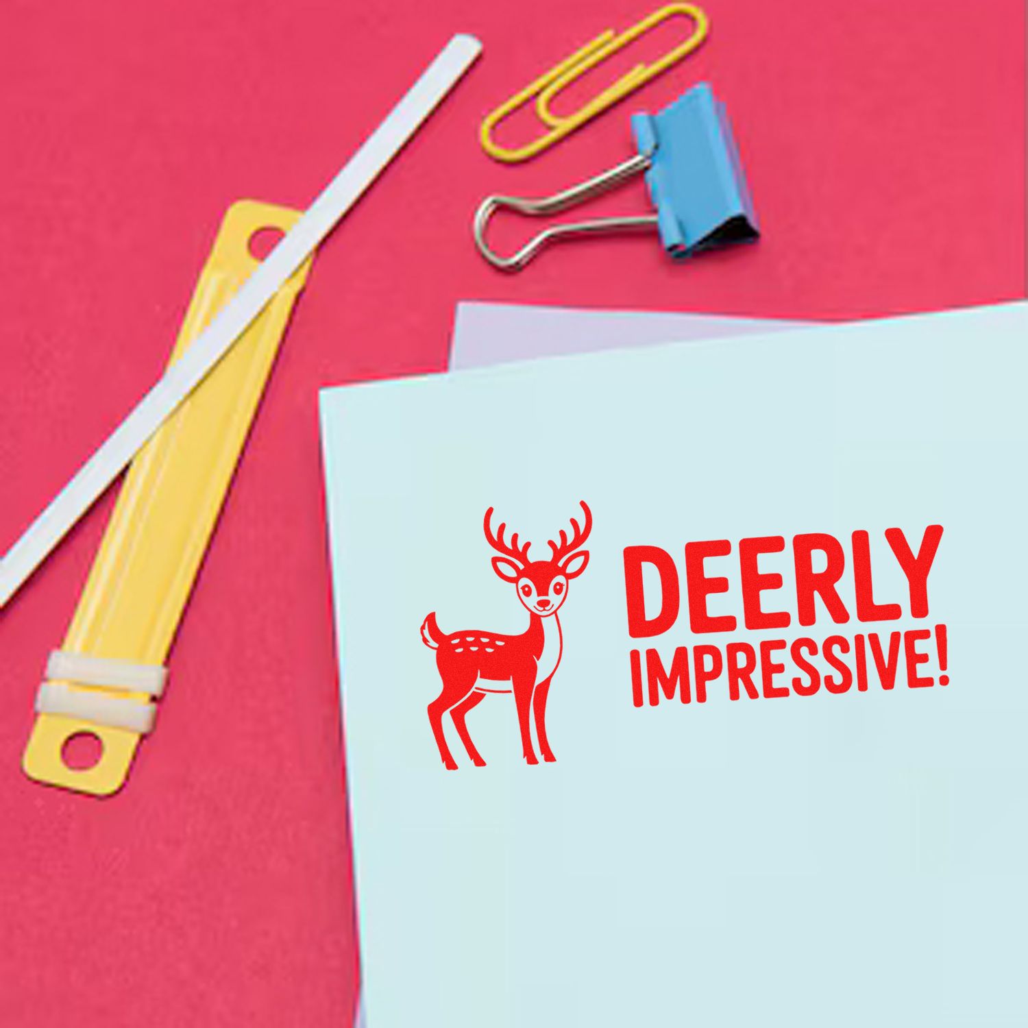 Custom stamp and seal design with red deer and DEERLY IMPRESSIVE on light blue card, set on a bright pink background.