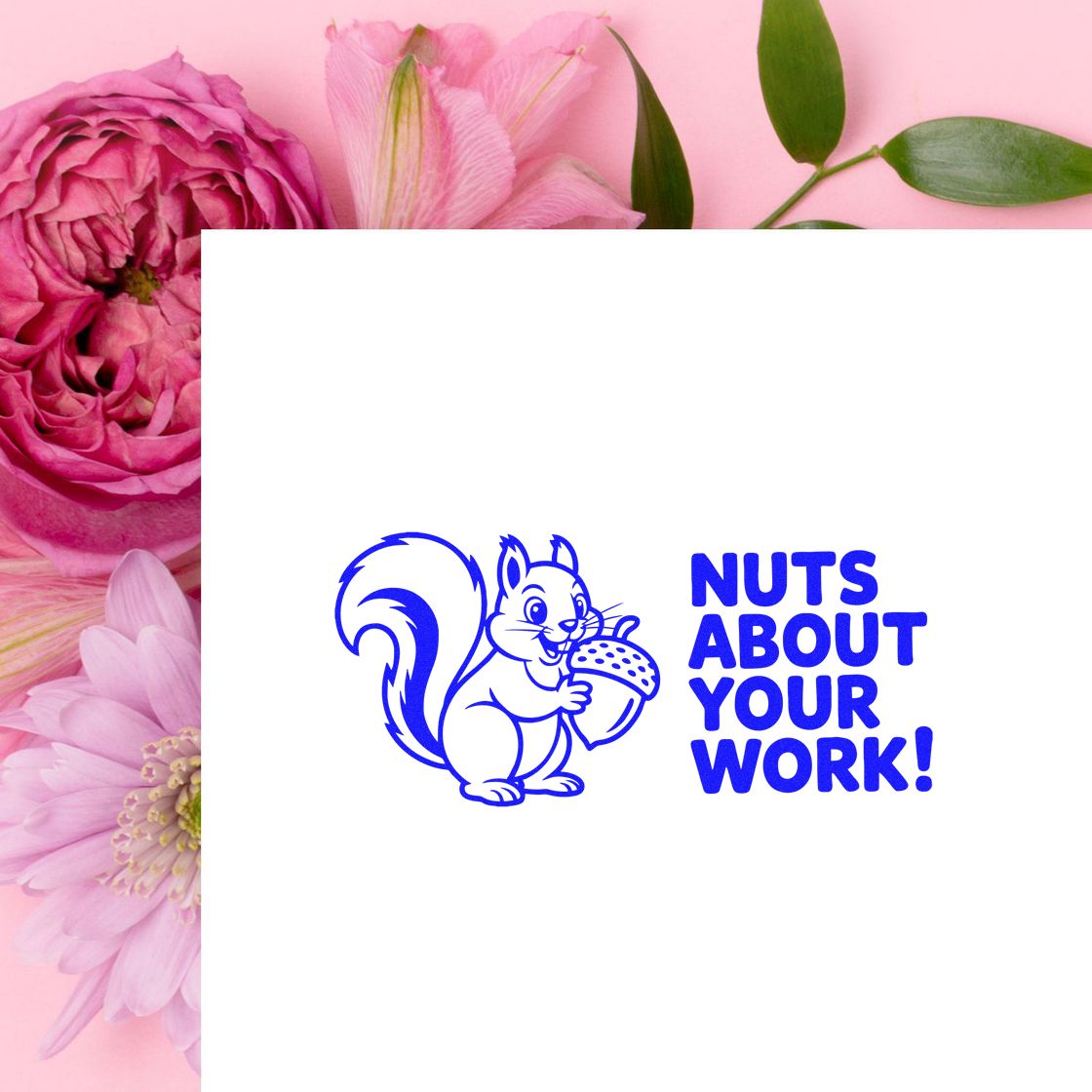 Blue rubber stamp/seal with squirrel holding an acorn and Nuts About Your Work! on white, against a pink floral background.