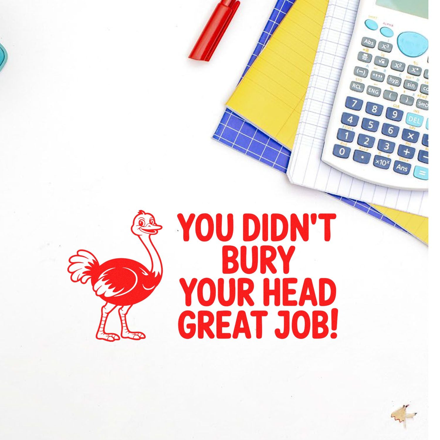 Red ostrich stamp seal with bold You didnt bury your head, great job! text, beside calculator and colorful notebooks.