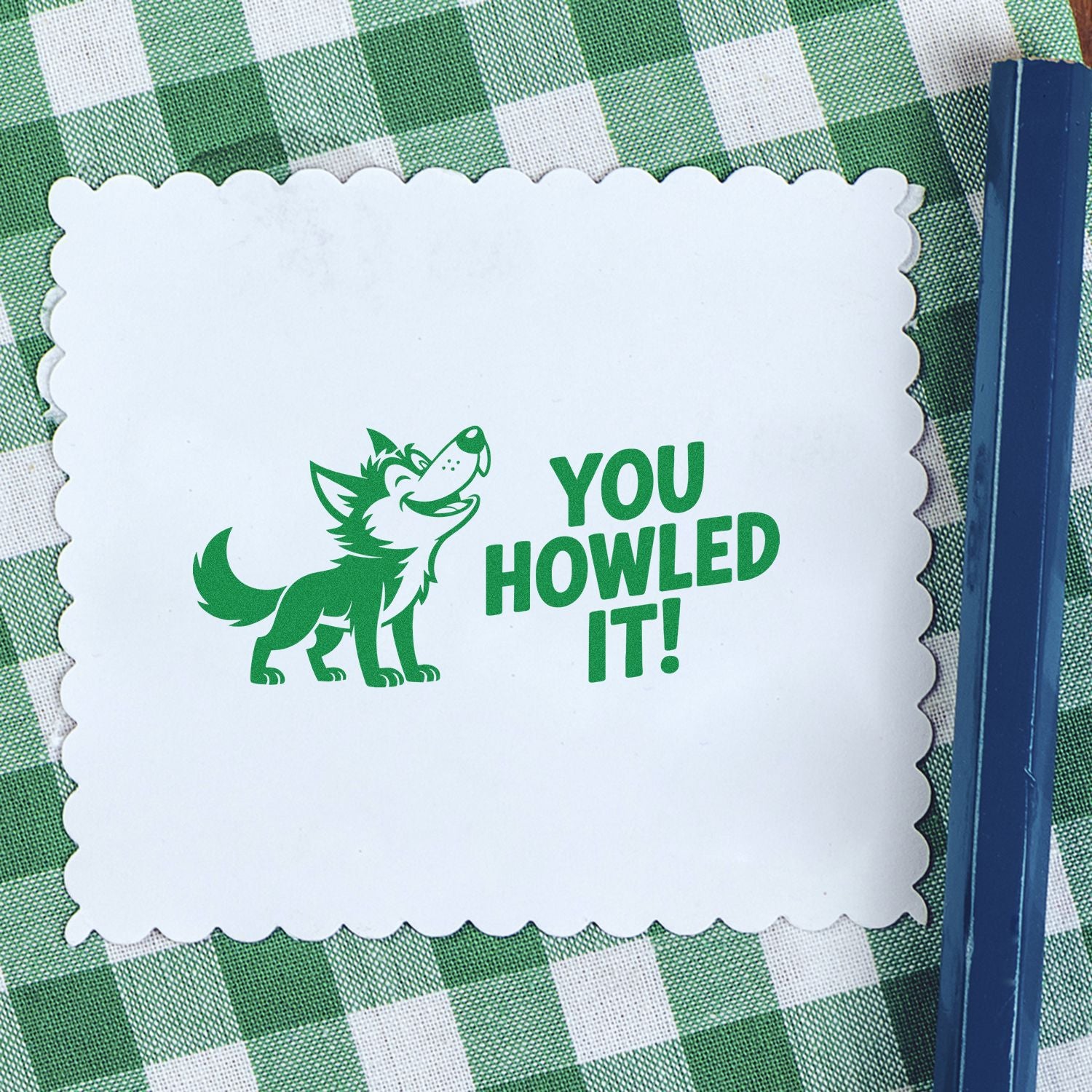 Green wolf stamp seal on white scalloped card with YOU HOWLED IT! on green gingham background.
