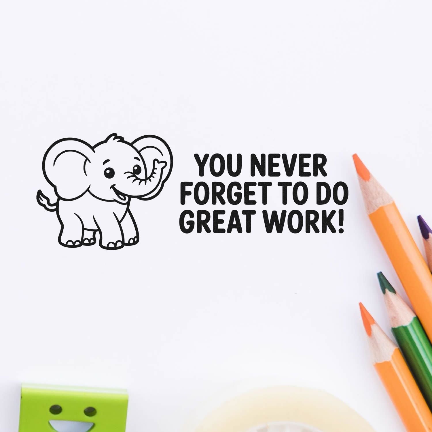 Black elephant stamp seal with You never forget to do great work! beside orange and green pencils.