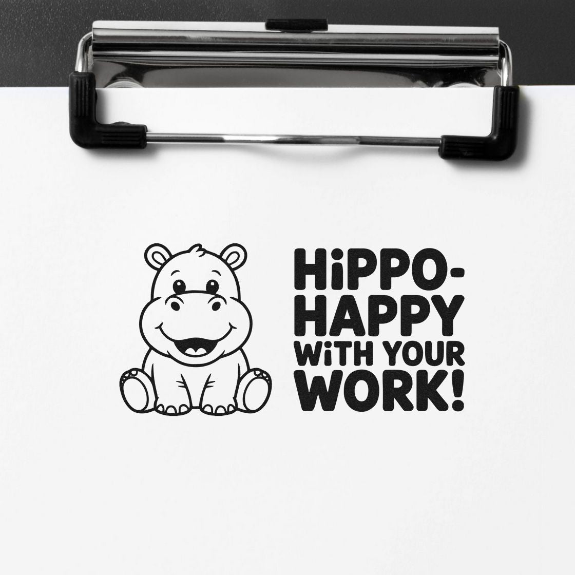 Black self-inking stamp seal with smiling hippo and bold Hippo-happy with your work! text on white paper.