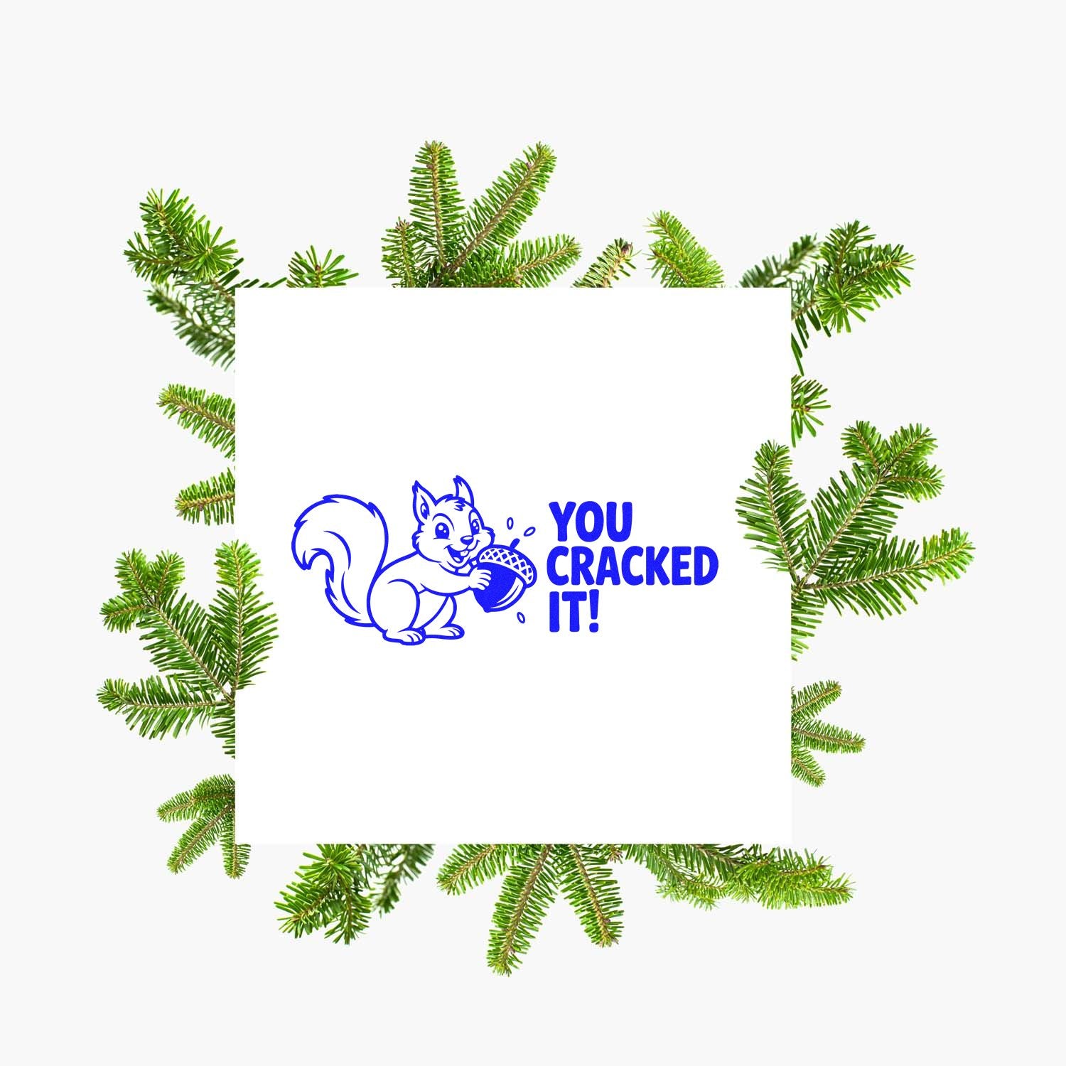 Blue rubber stamp seal with squirrel and You Cracked It! on white, framed by green evergreen branches.