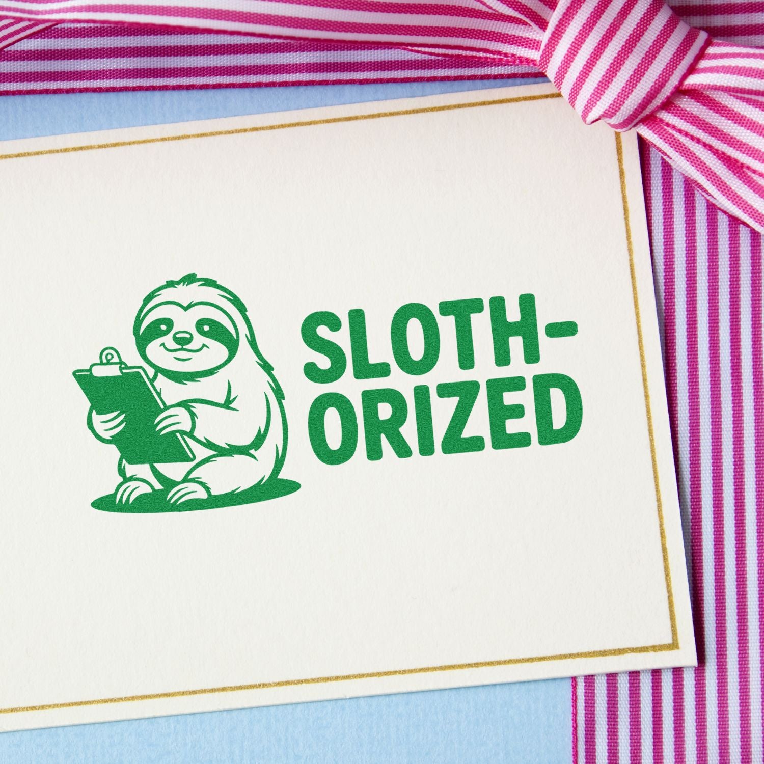 Green sloth approval stamp with clipboard and SLOTH-ORIZED text on white card, gold border, pink striped ribbon.