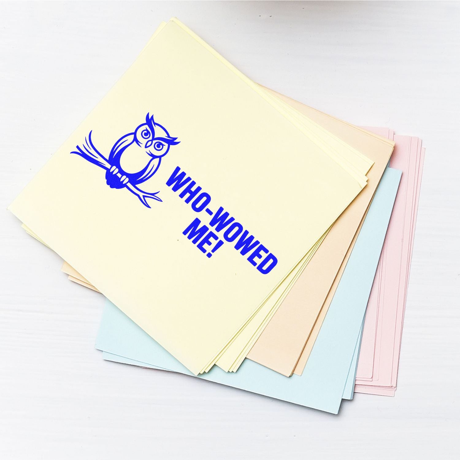 Pastel stamp and seal sheets with blue owl and bold blue WHO-WOWED ME! imprint on cream, pink, and blue paper.