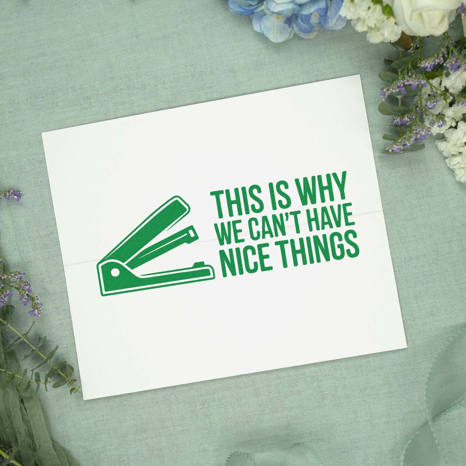 Green stamp and seal card with stapler icon and slogan This is why we cant have nice things on pale floral fabric.